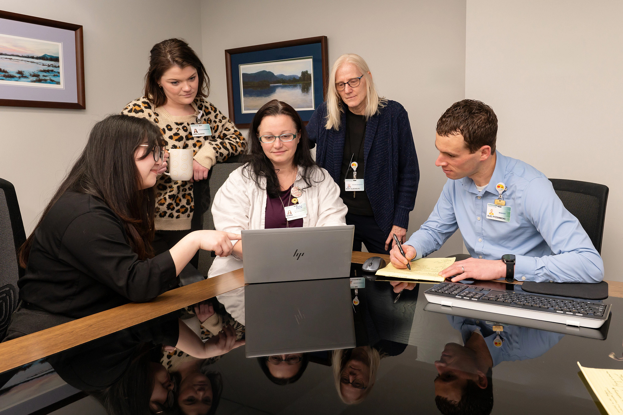 Five research navigation professionals collaborating in conference room.