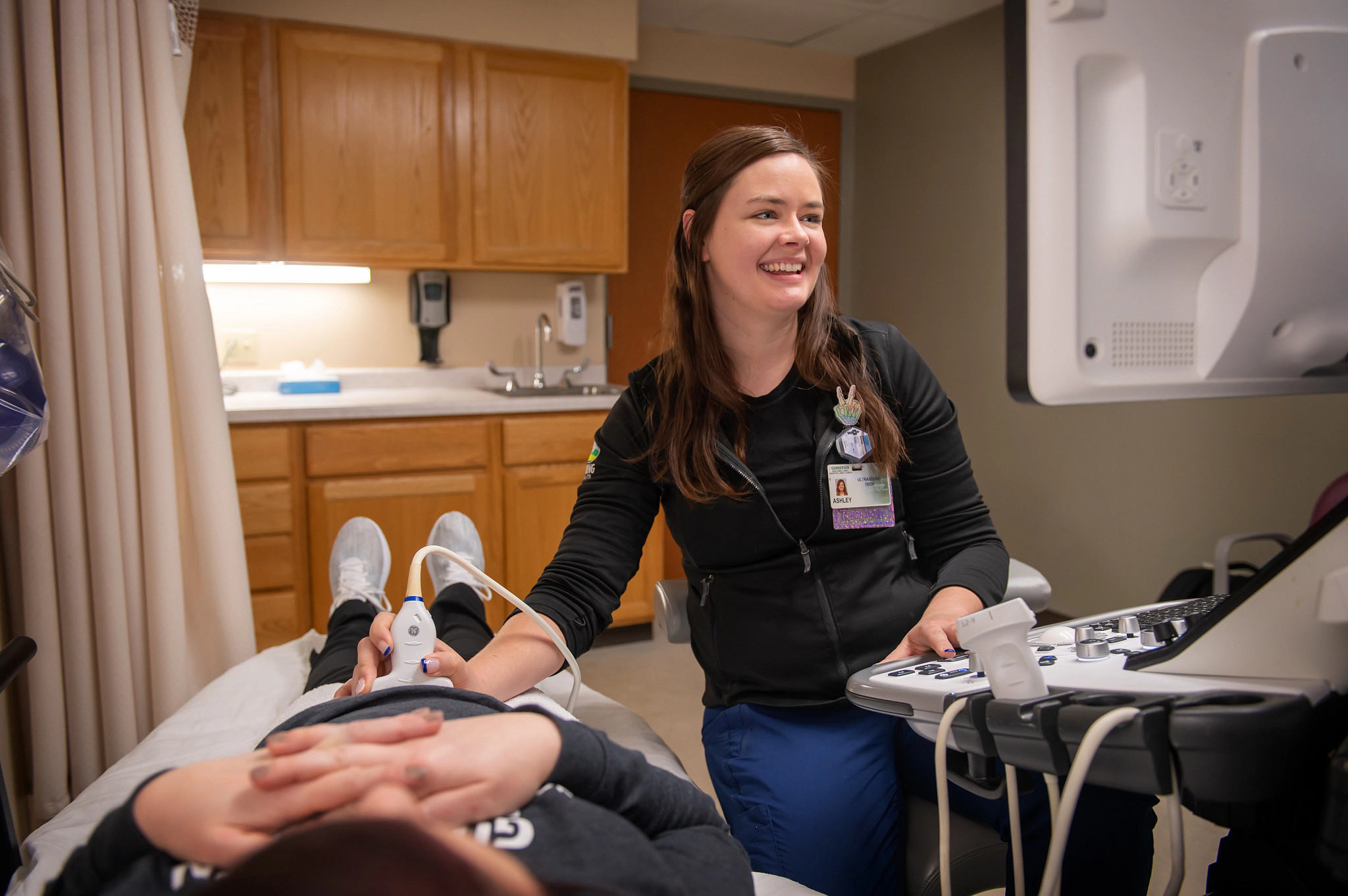 Radiologist examining patient with ultrasound wand.