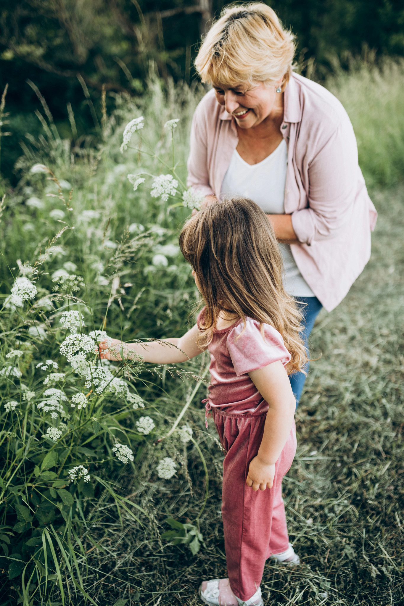 Grandmother and her young granddaughter walking in a field