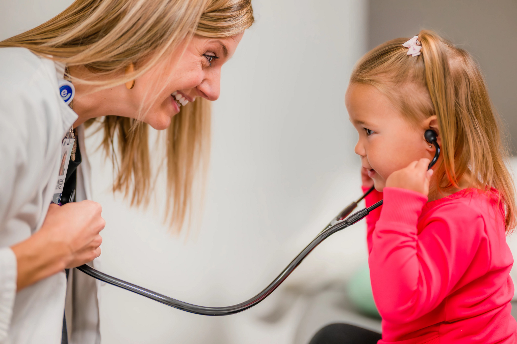 Young girl patient listening to the heart of a provider with a stethoscope