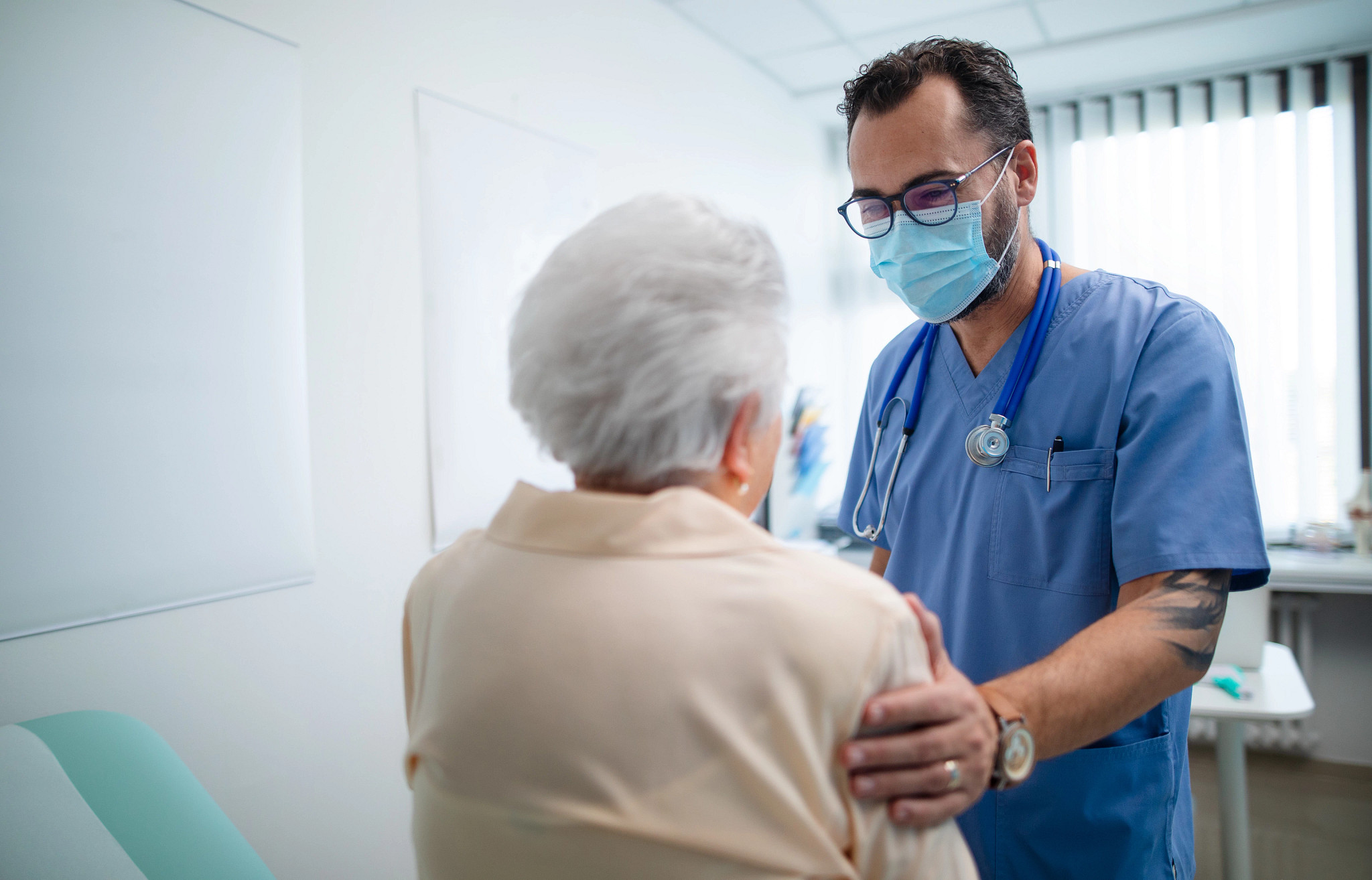 Doctor with elderly patient in examination room