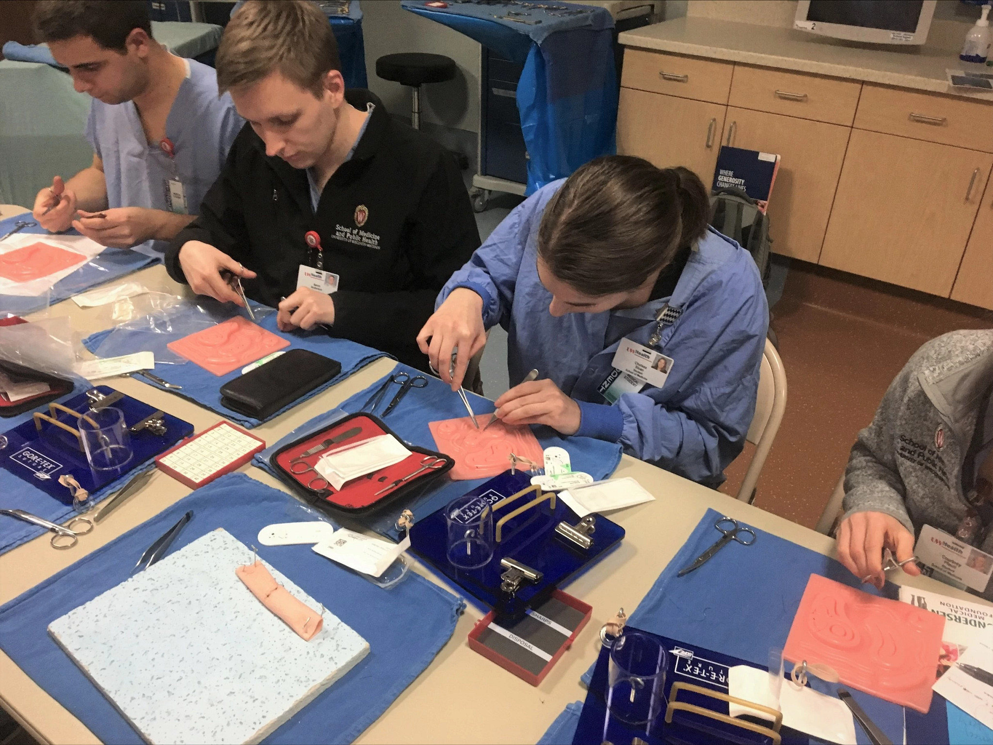 Medical students learning surgical skills in simulation lab.
