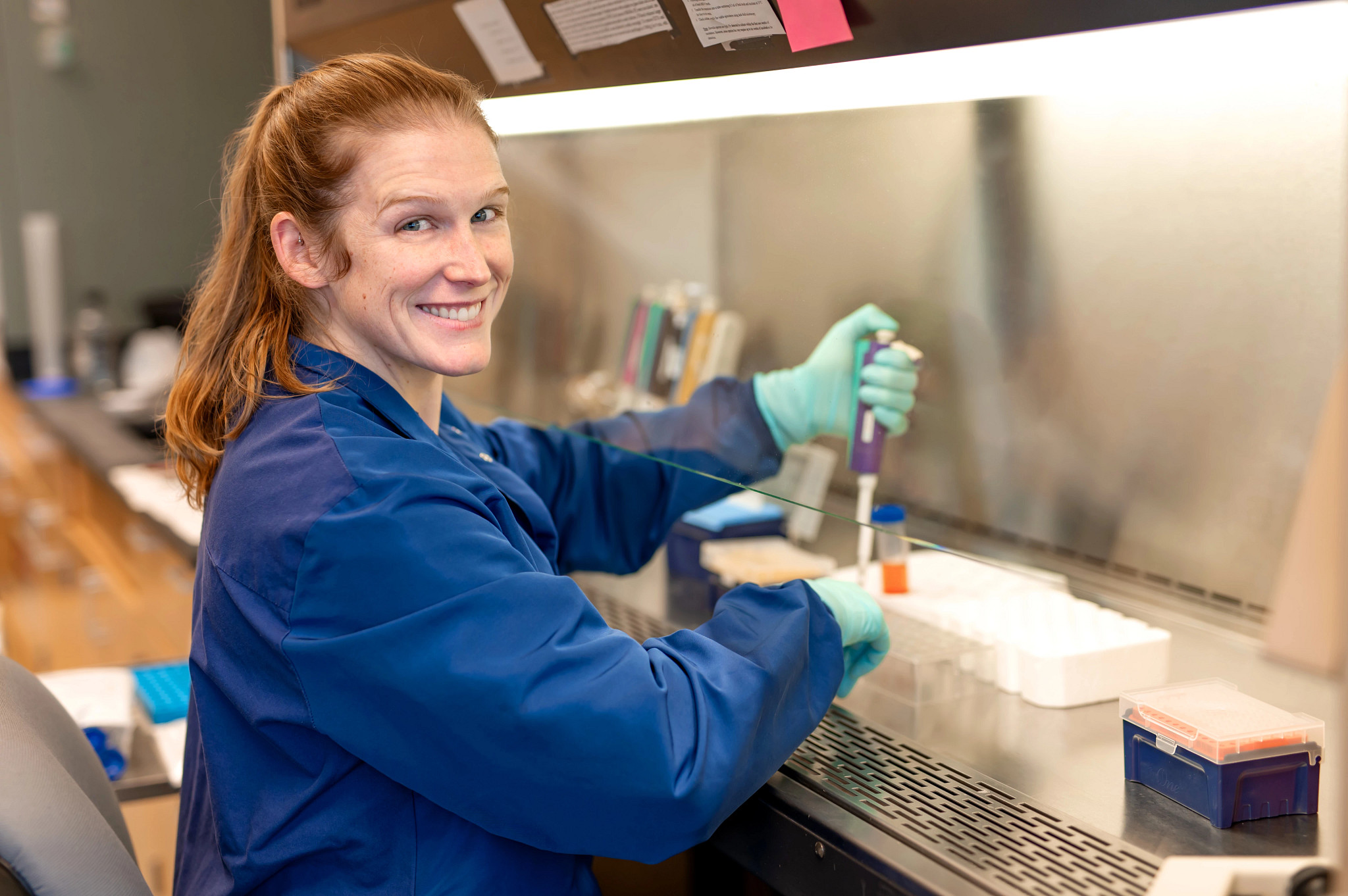 Female Lyme disease researcher smiling at camera while working.
