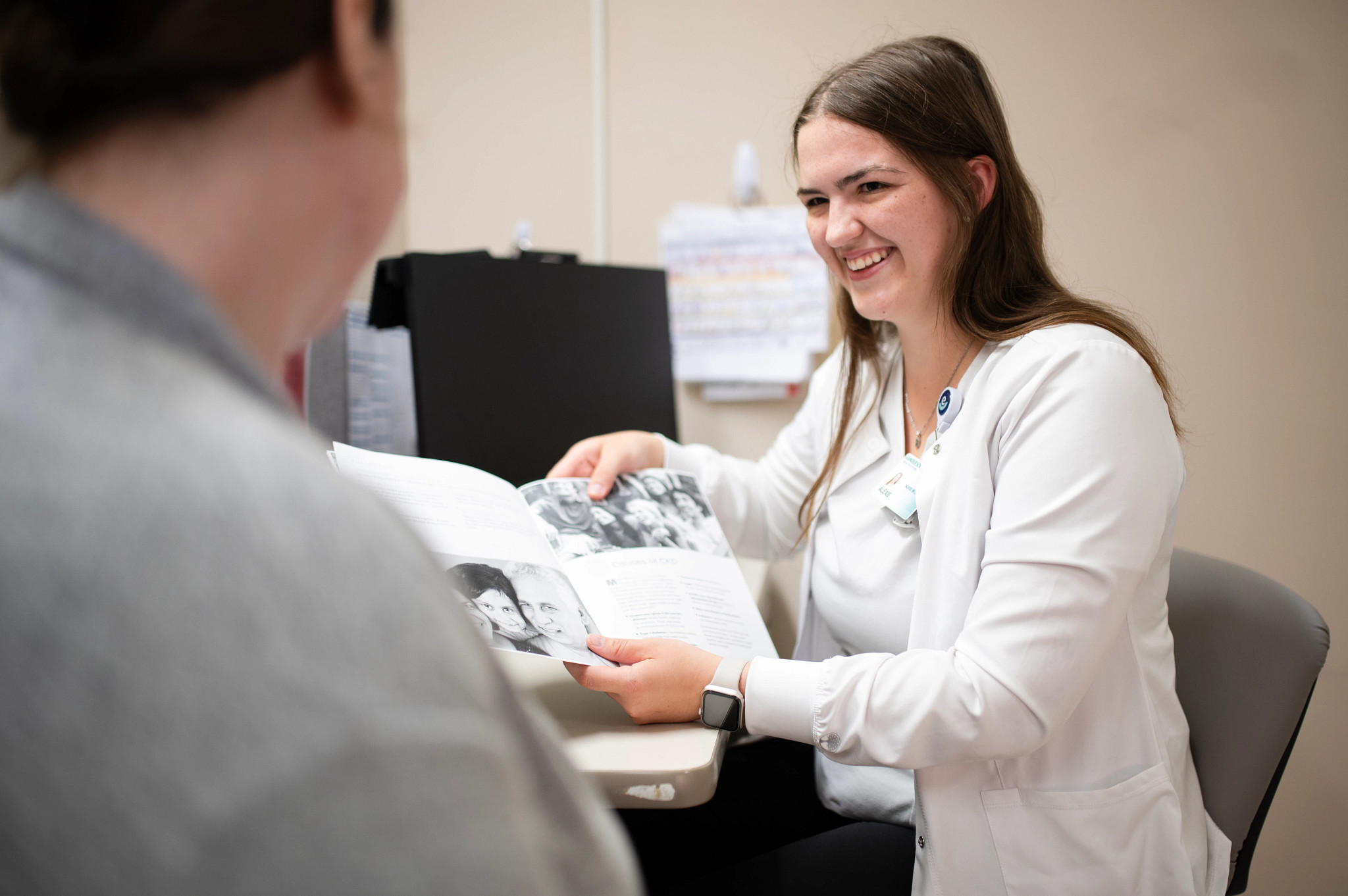 Nurse intern teaching patient in the exam room.