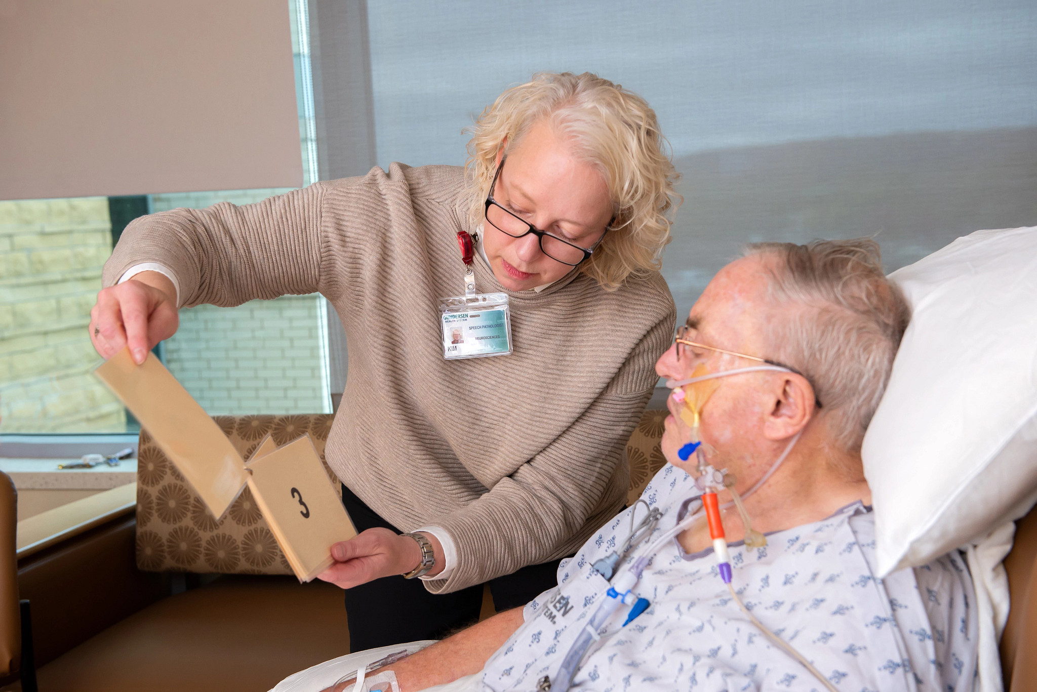 Male Gundersen stroke patient and stroke provider in hospital room.