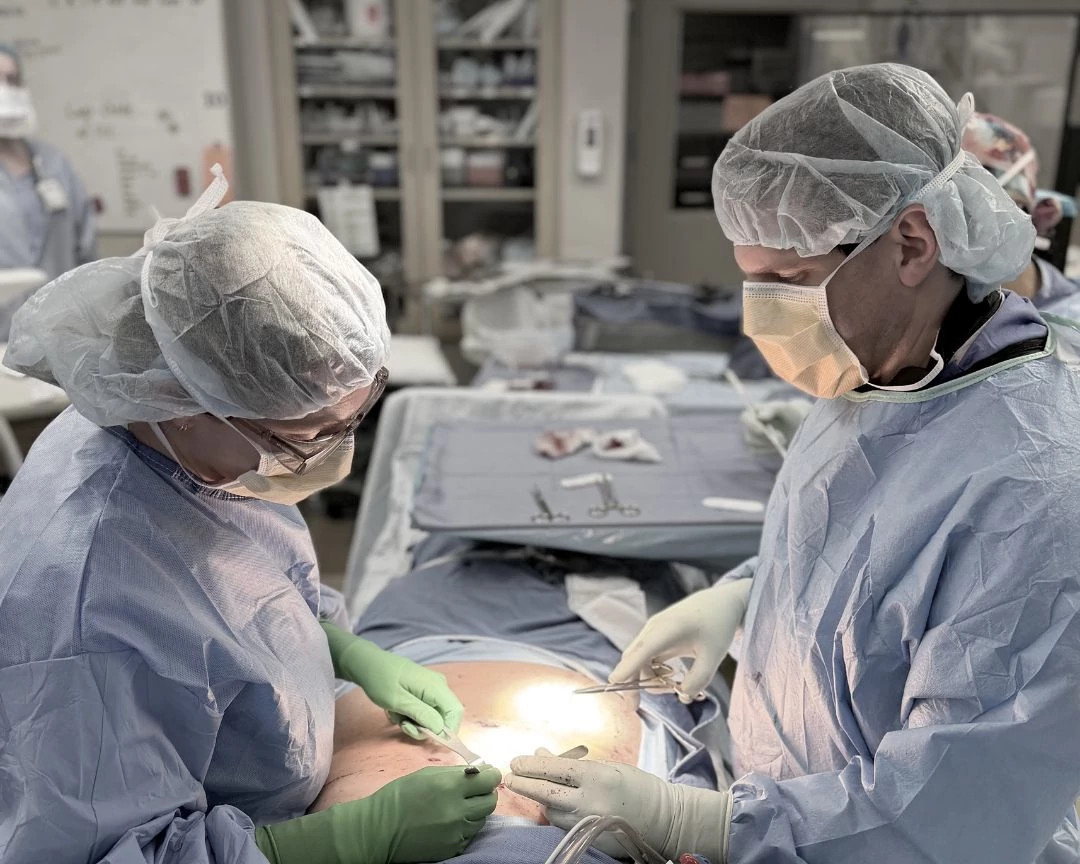Two general surgeons performing abdominal surgery in the operating room.