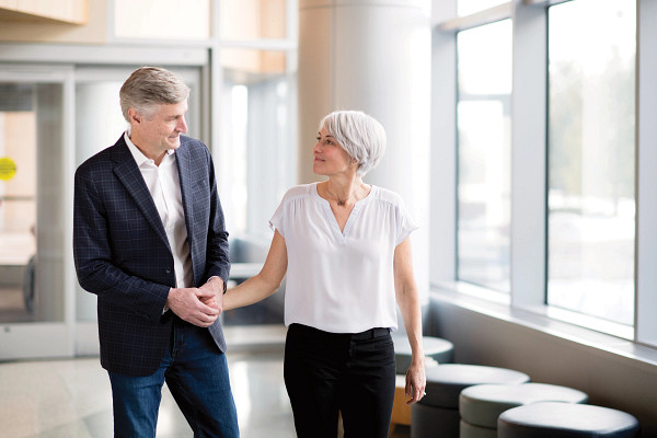 Mature couple holding hands inside lobby.