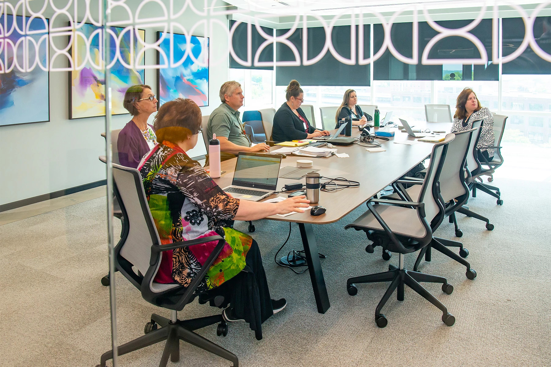 Hospice fellowship leaders meeting in modern conference room.