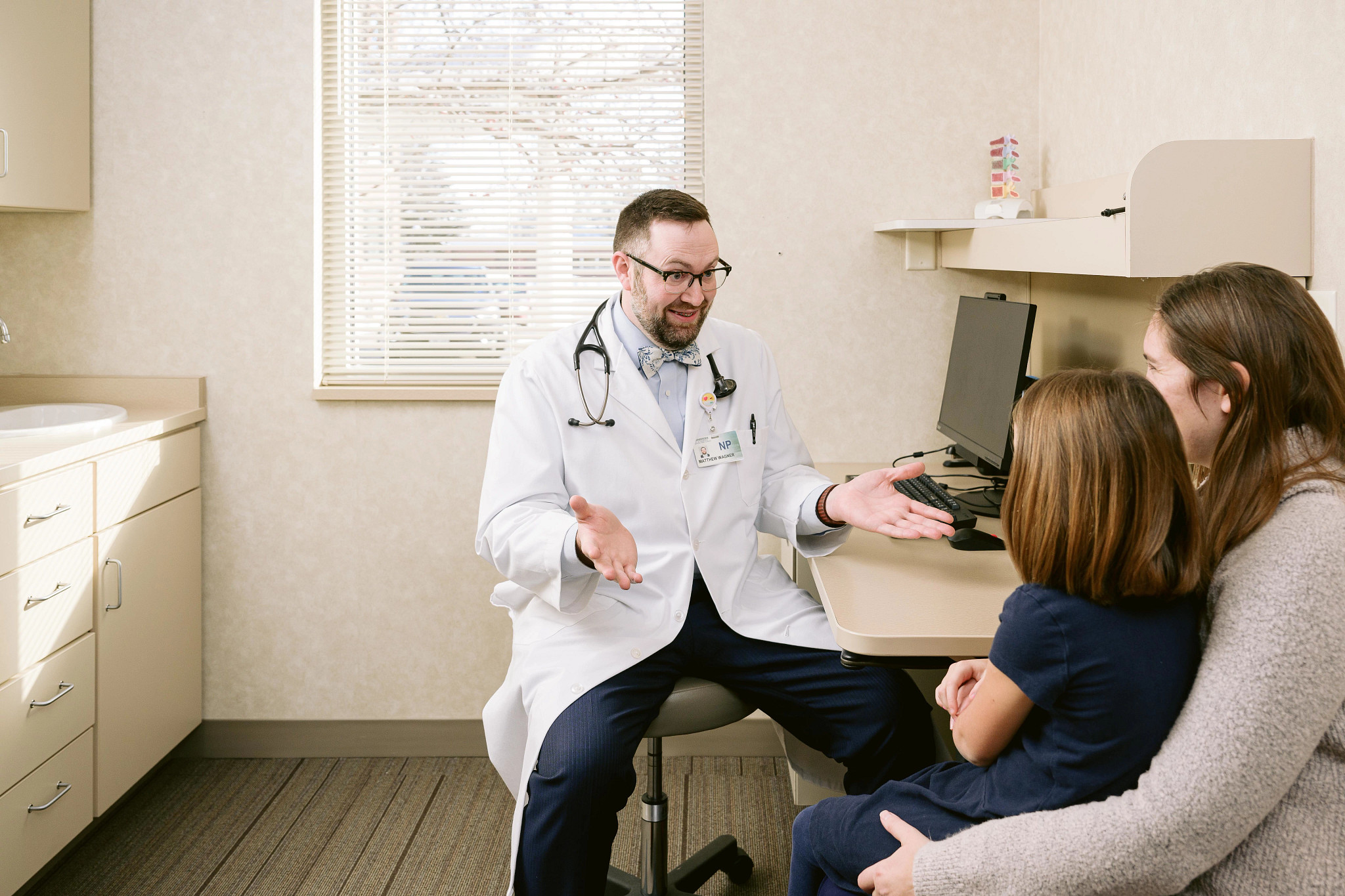 male-nurse-speaking-with-mother-and-daughter