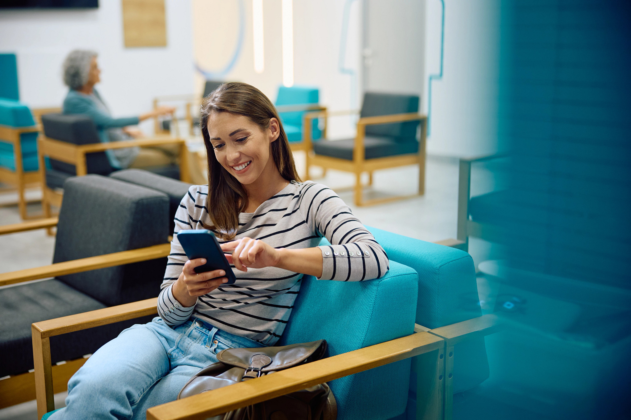 Happy woman using her cell phone in a healthcare setting.