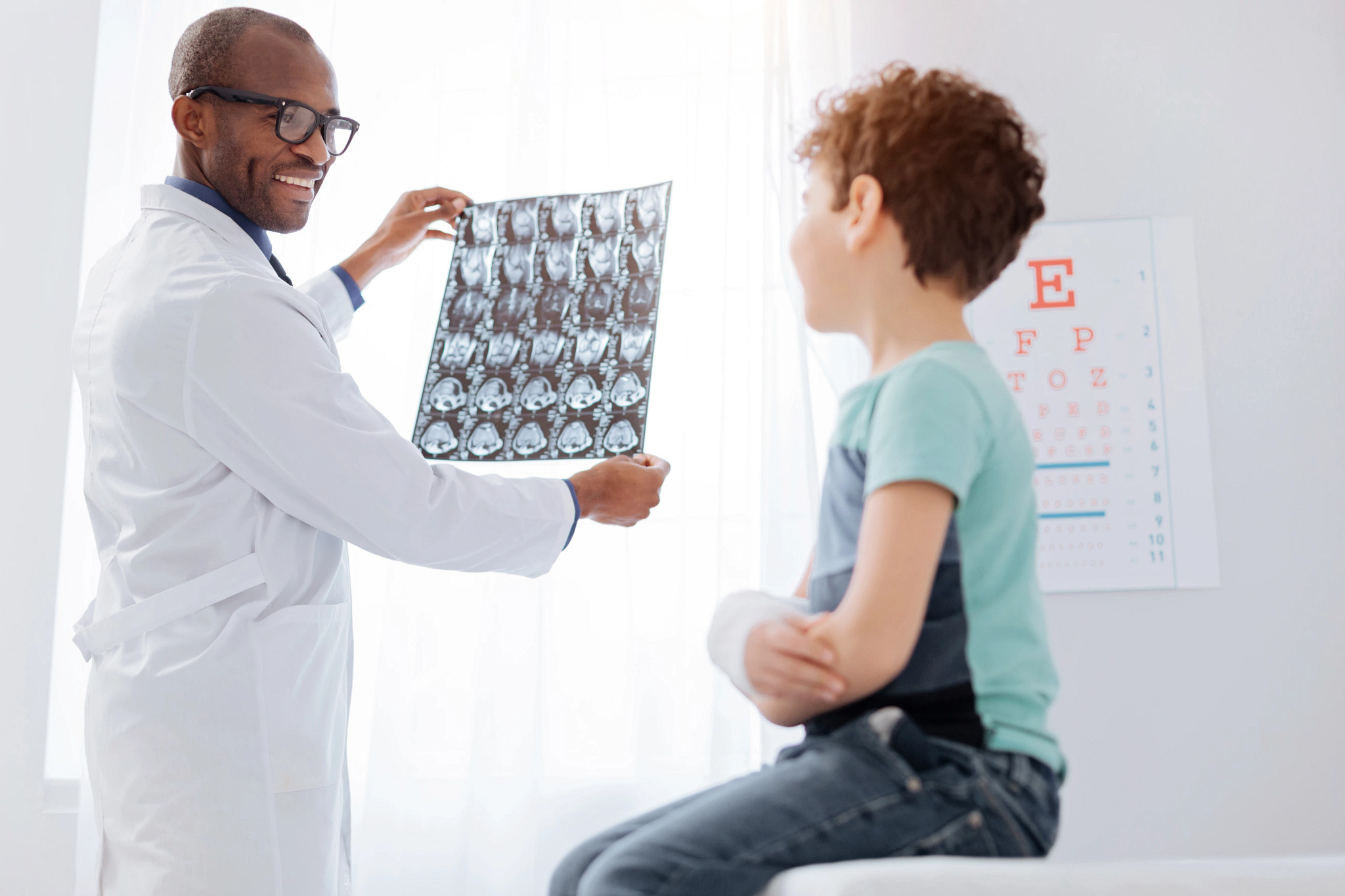 Happy male doctor showing brain imaging to boy