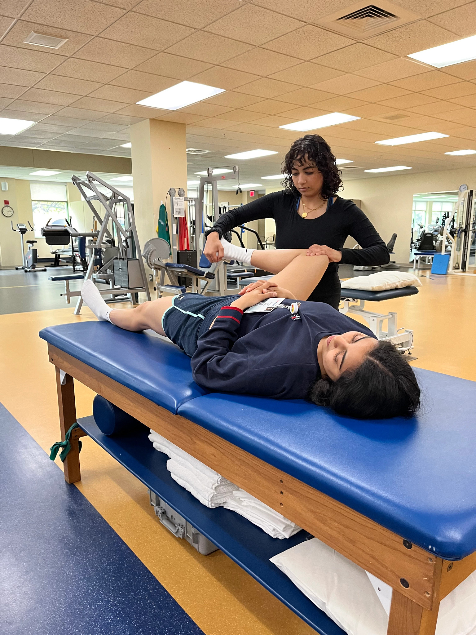 Medical student performing a knee exam on a patient