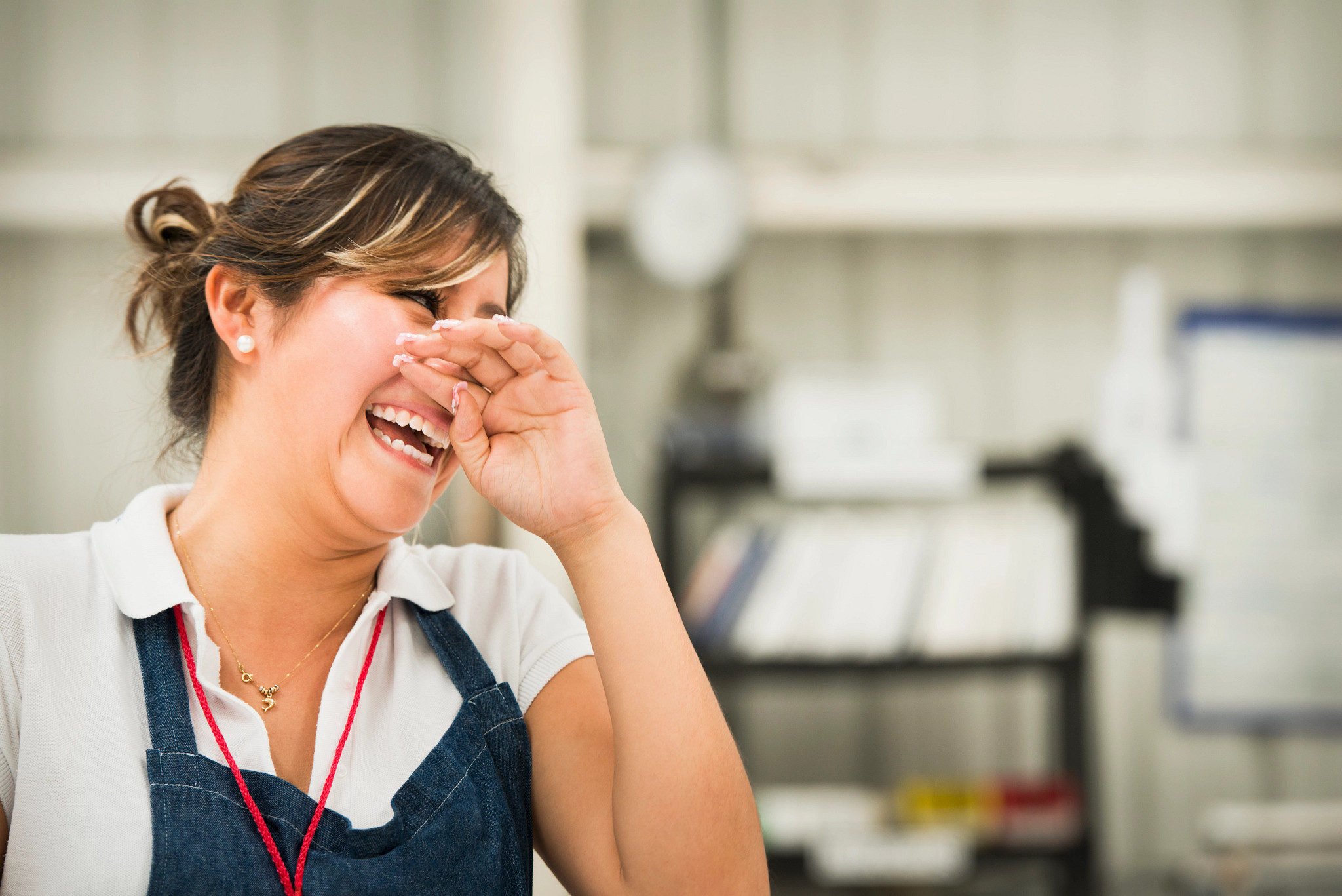 Female worker laughing in manufacturing plant