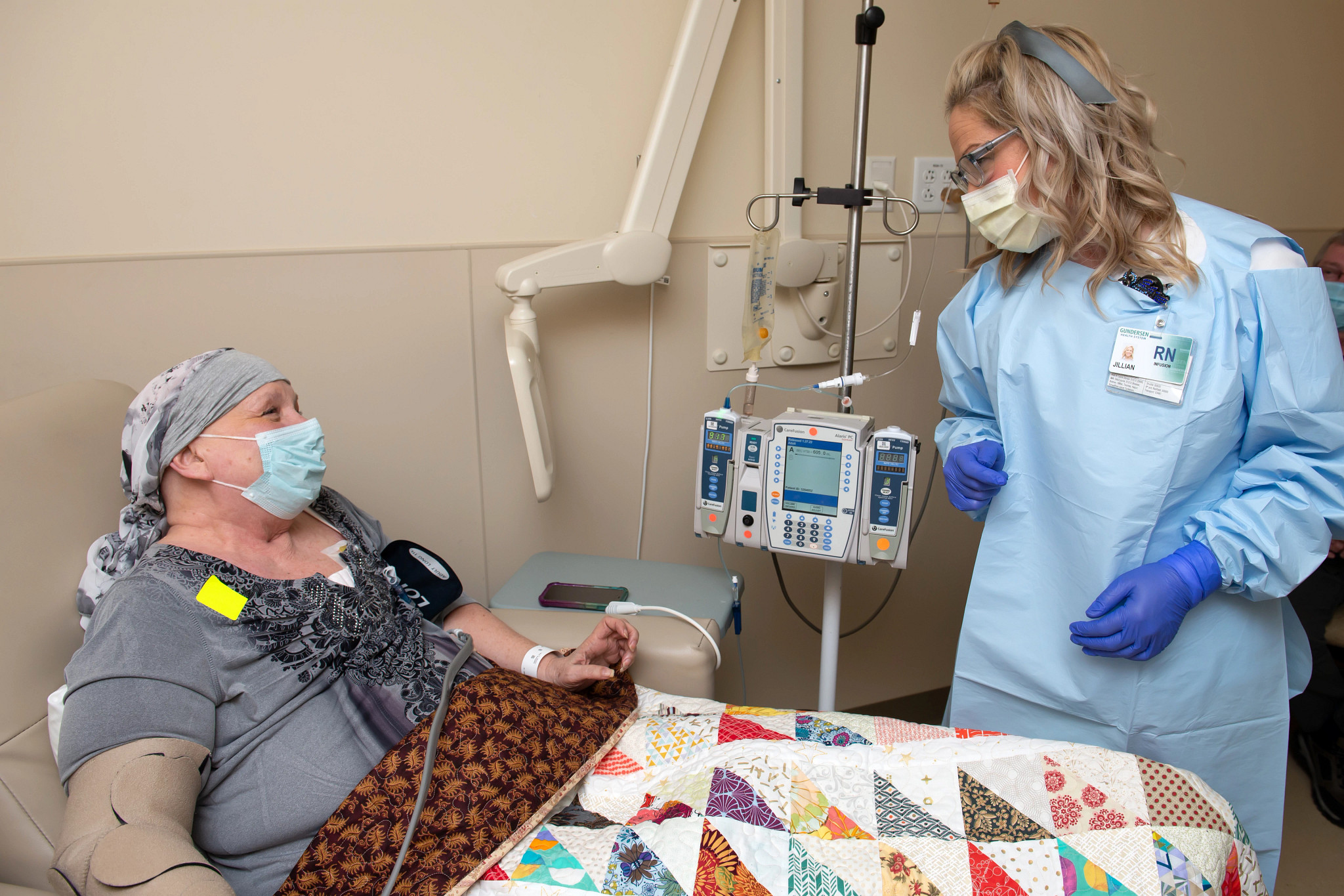 Infusion therapy nurse assists patient during treatment.