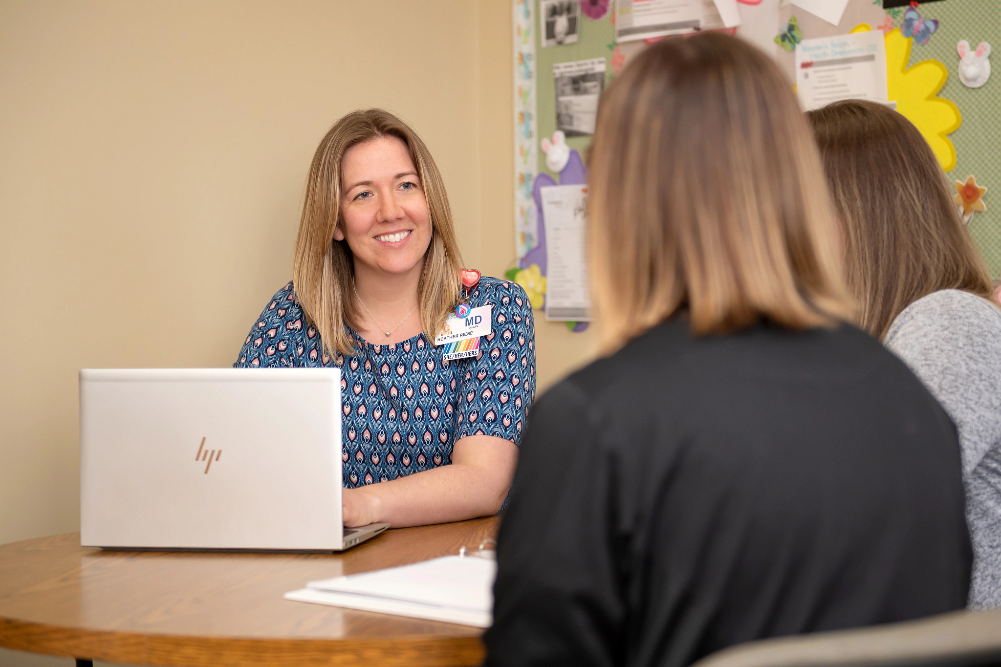 Gundersen doctor seated at table speaking to two women.