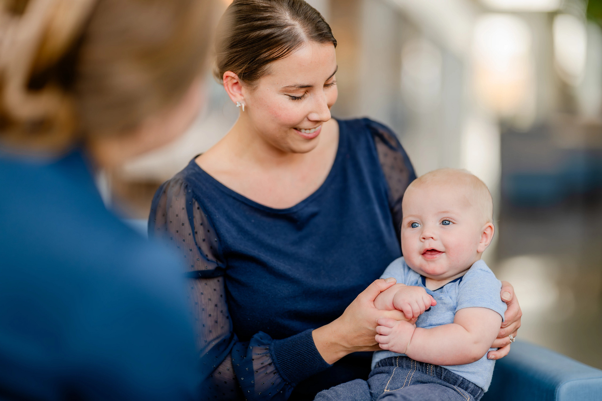 A mom holding her baby in the lobby