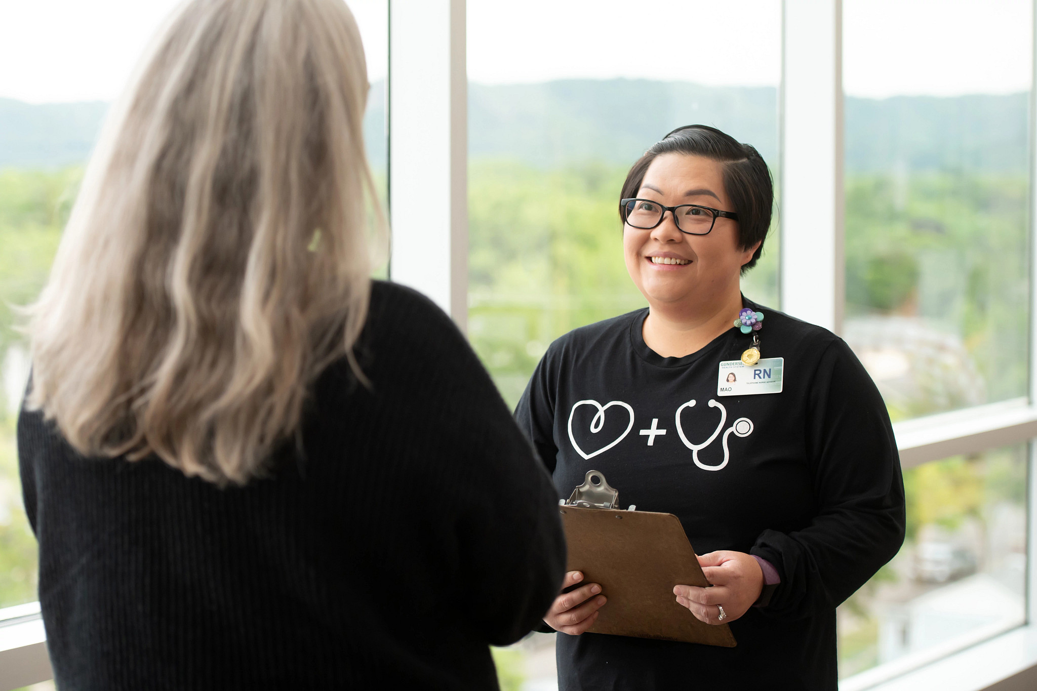 Nurse speaking and smiling at patient.