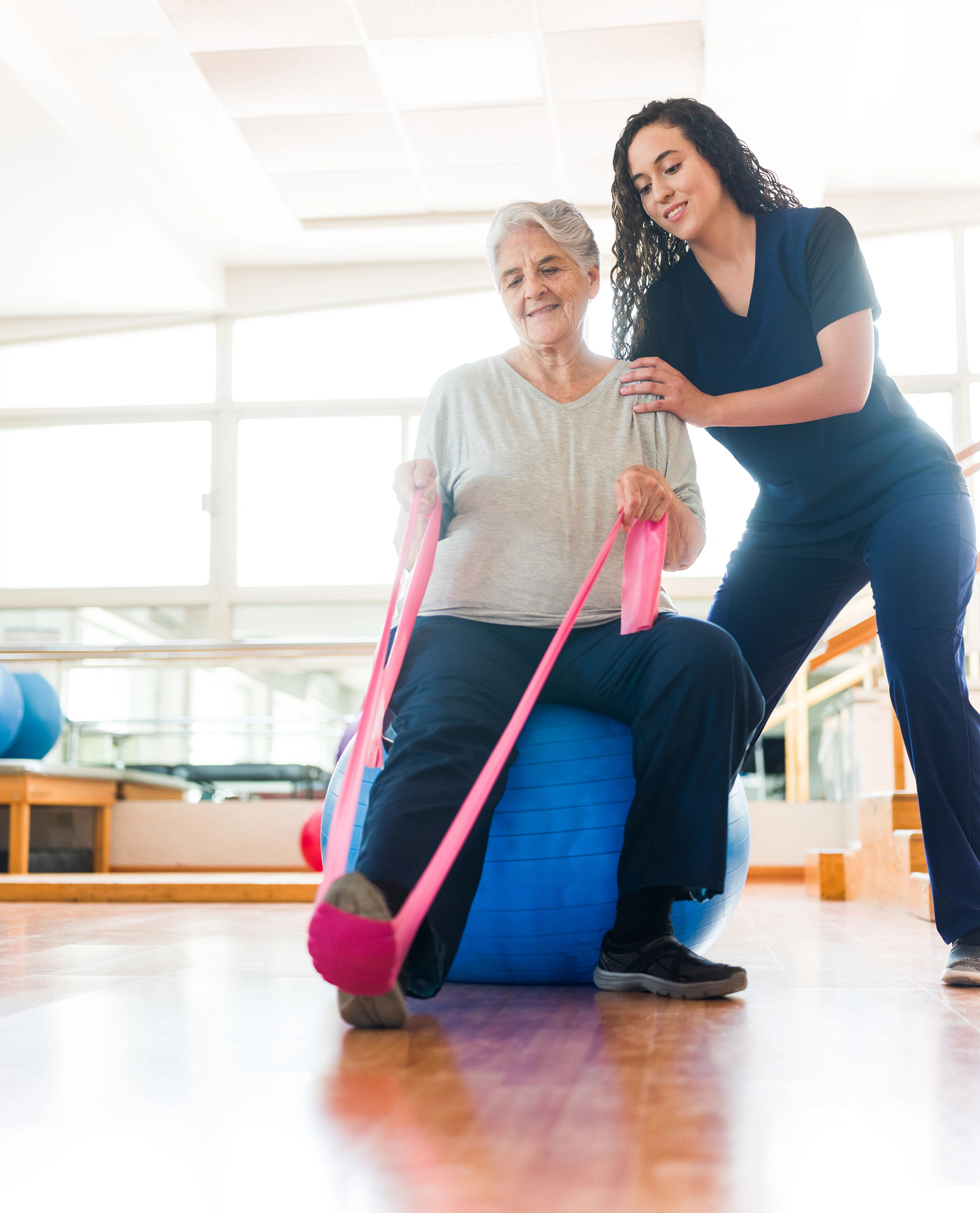 Senior woman stretching leg with exercise band