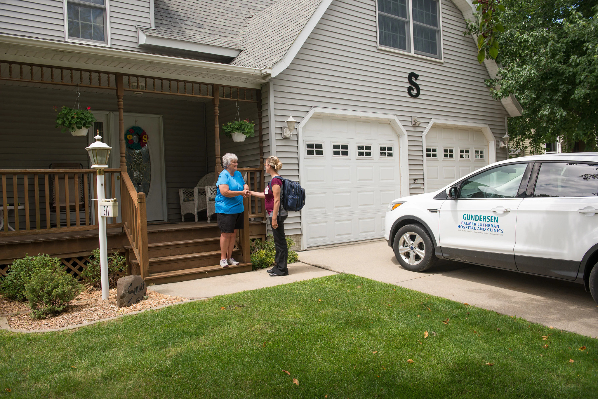 Home Health nurse and patient outside home.