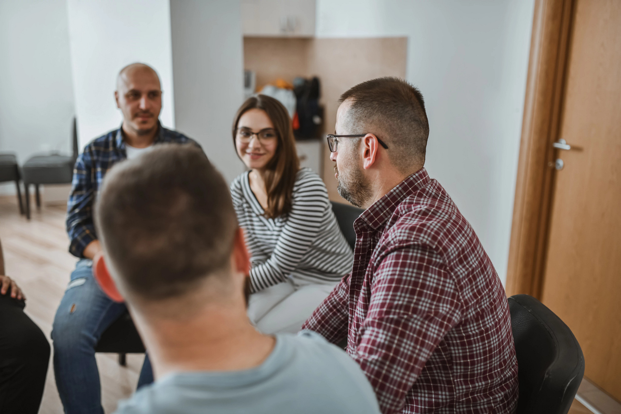 Group of men and women listening to man share story in support group