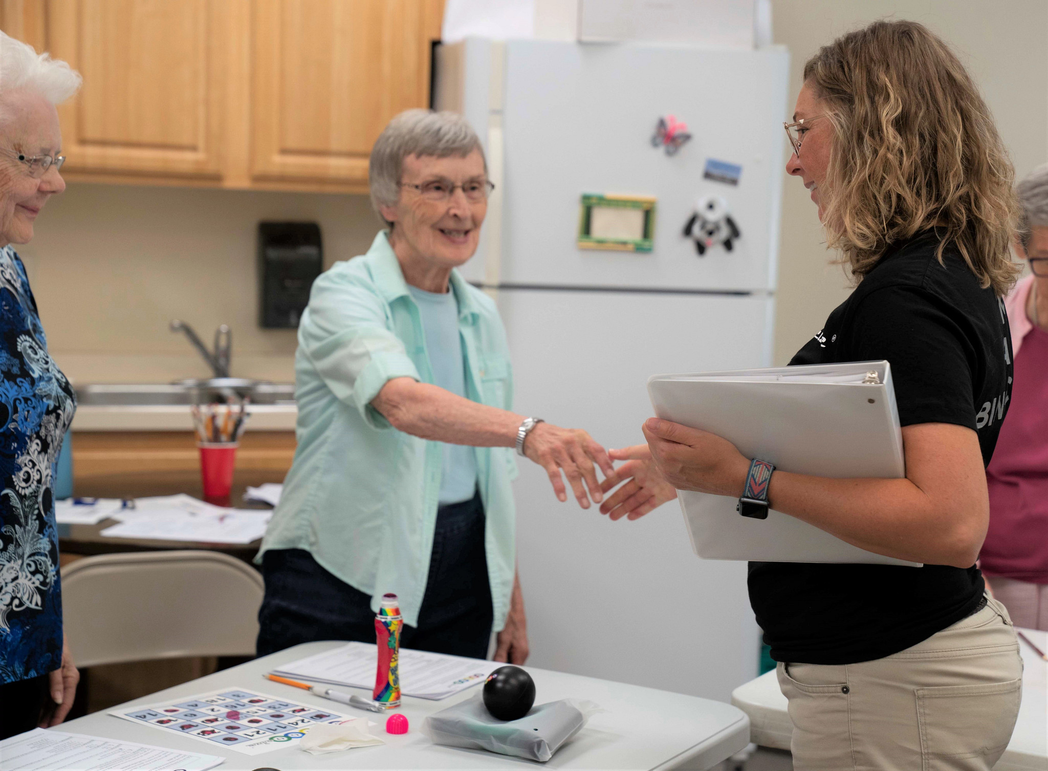 Senior shaking hands and smiling at public health employee.