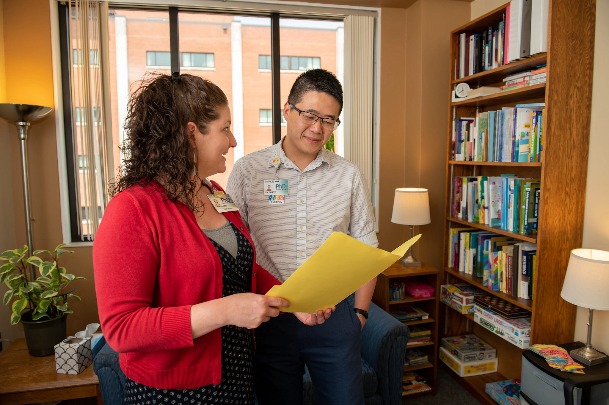 Psychologists collaborating with patient file in office.