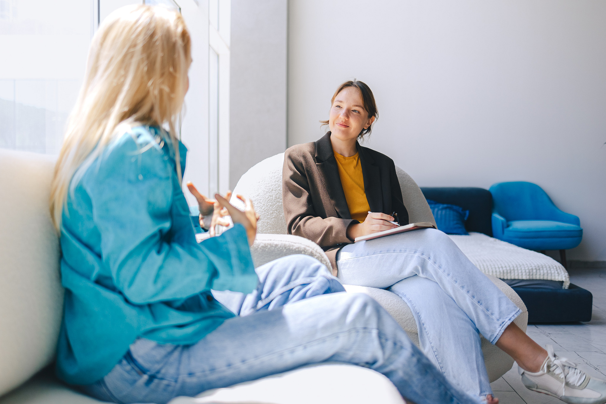 Two women having an outpatient counseling session in a bright room.