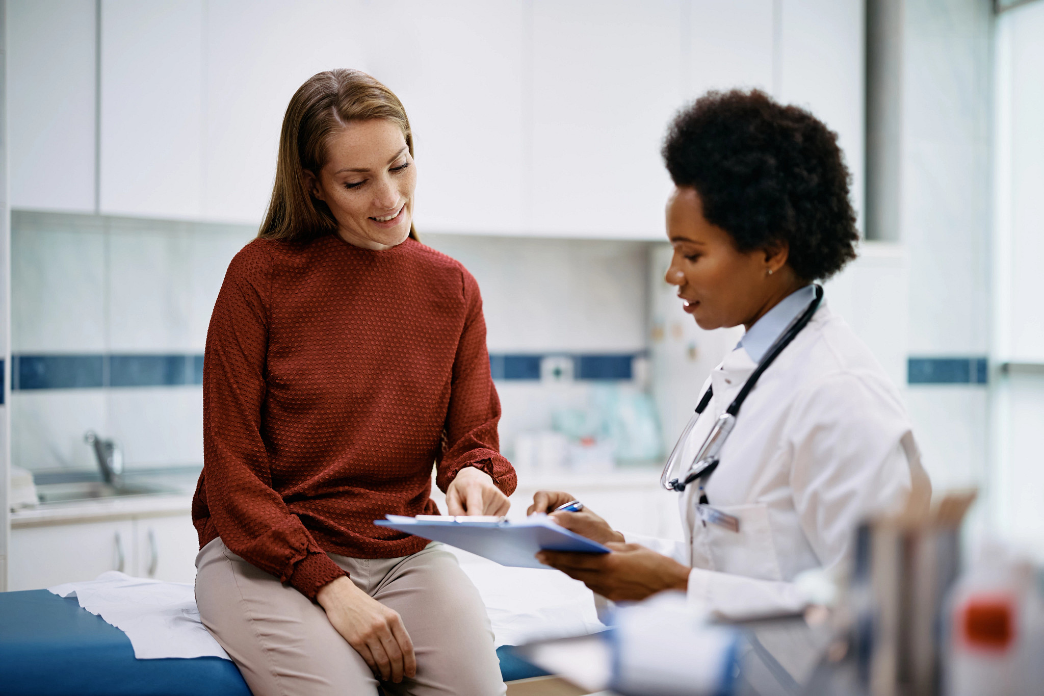 Happy woman going through her medical data with a female doctor