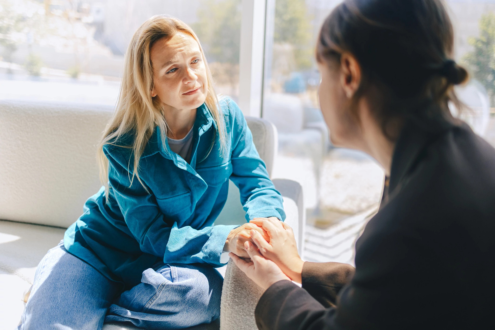Two middle-aged women holding hands.