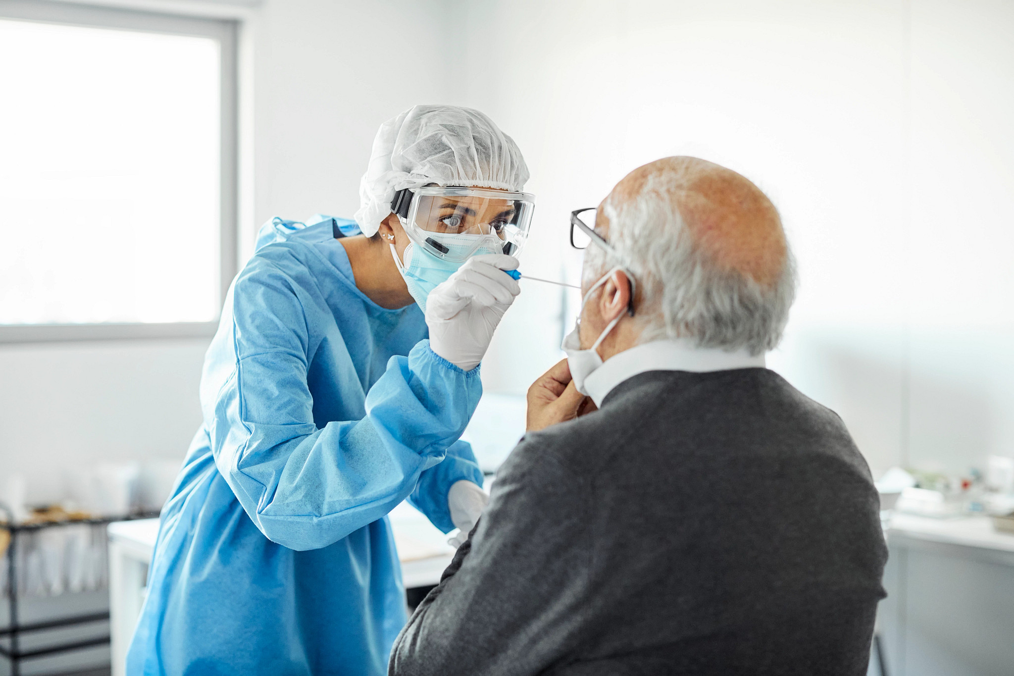 Doctor taking swab test sample of elderly patient