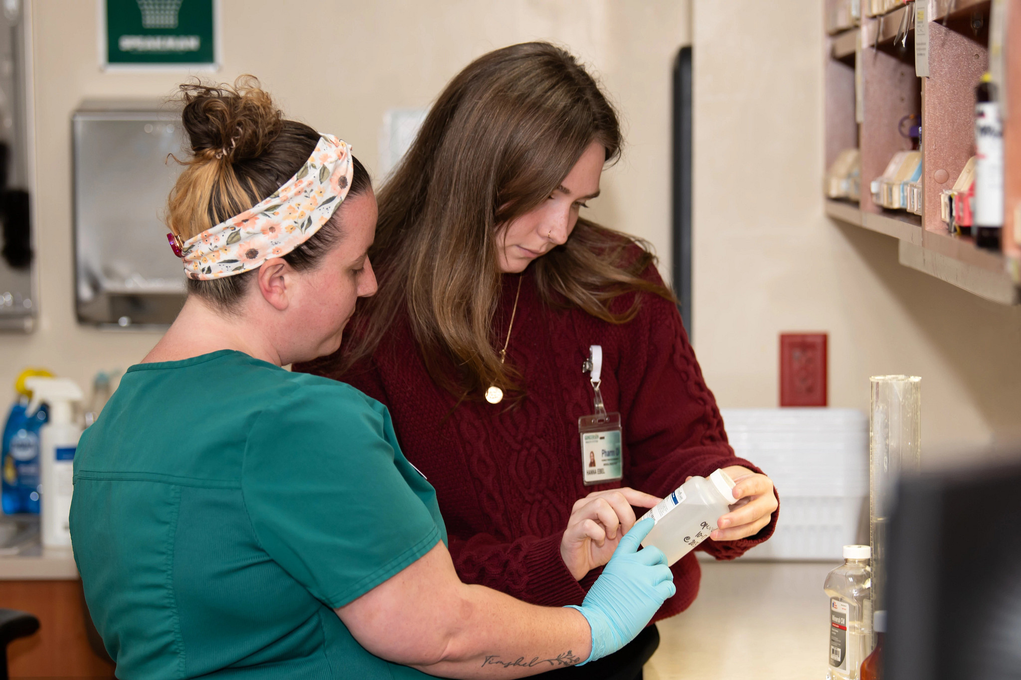 Gundersen Pharmacy resident looking at prescription bottle with colleague.