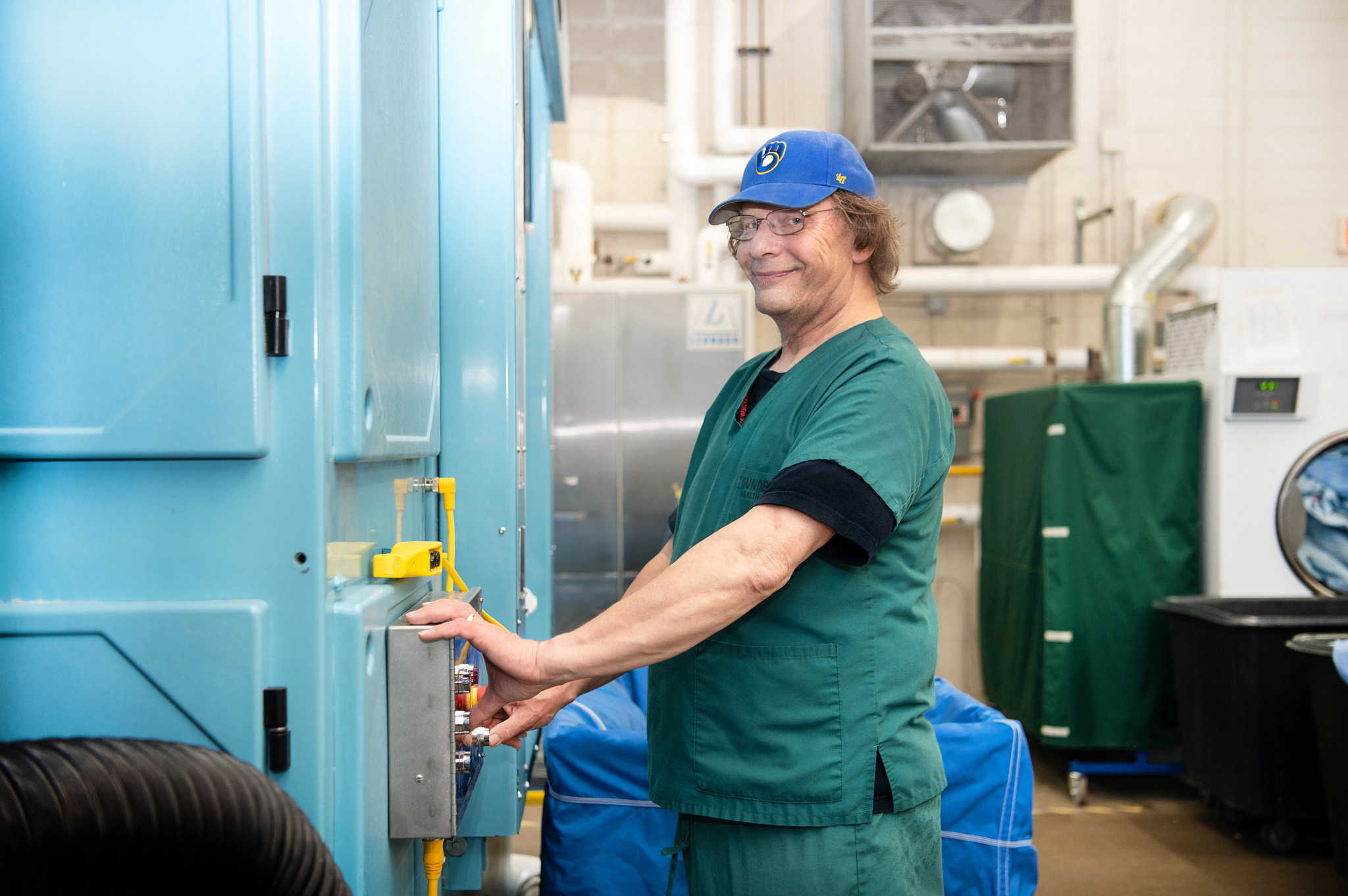 Washroom-operator-working-on-industrial-dryer