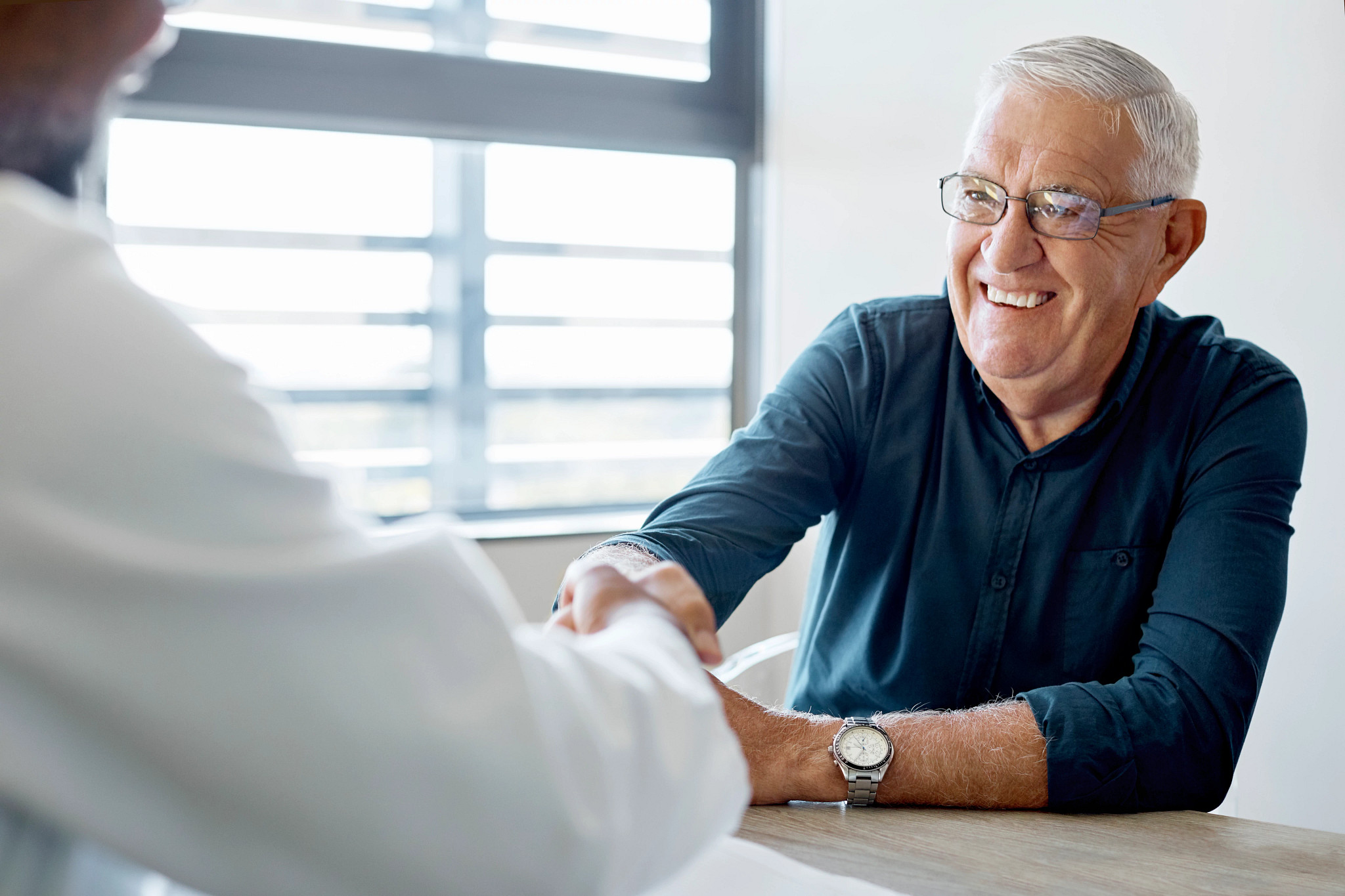 Senior man handshaking with male doctor.