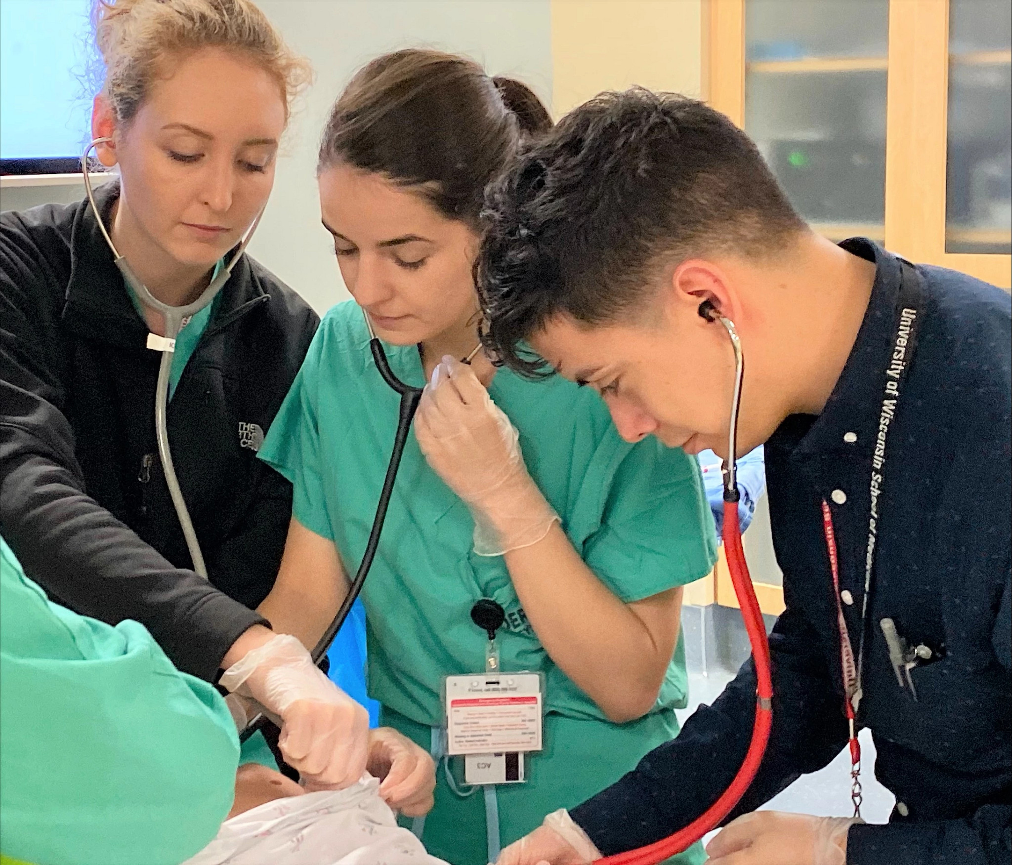 Medical students practicing with stethoscope.