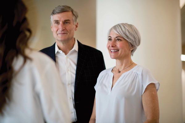 Senior couple talking to adult female doctor.