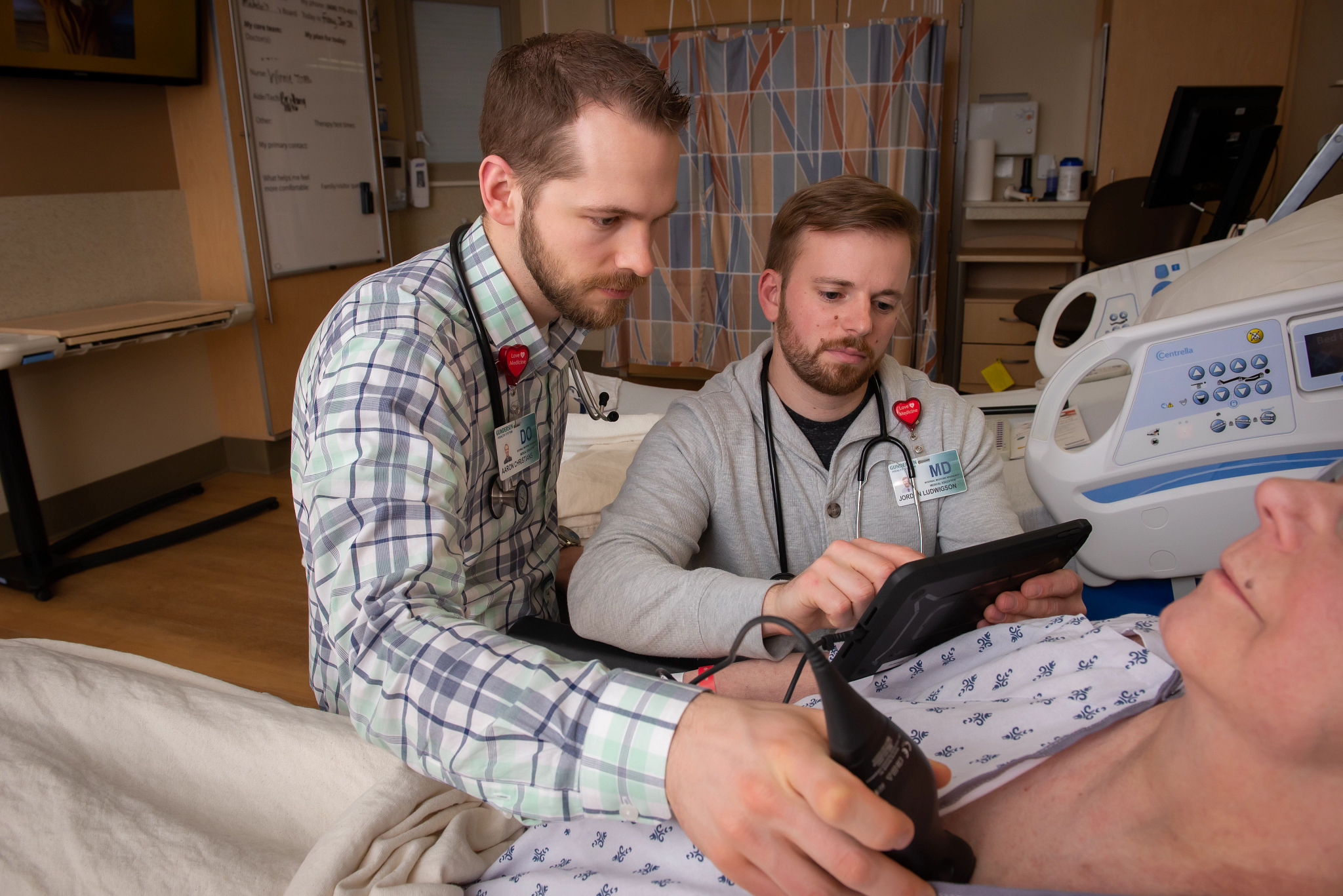 Medical education students using portable ultrasound on patient.