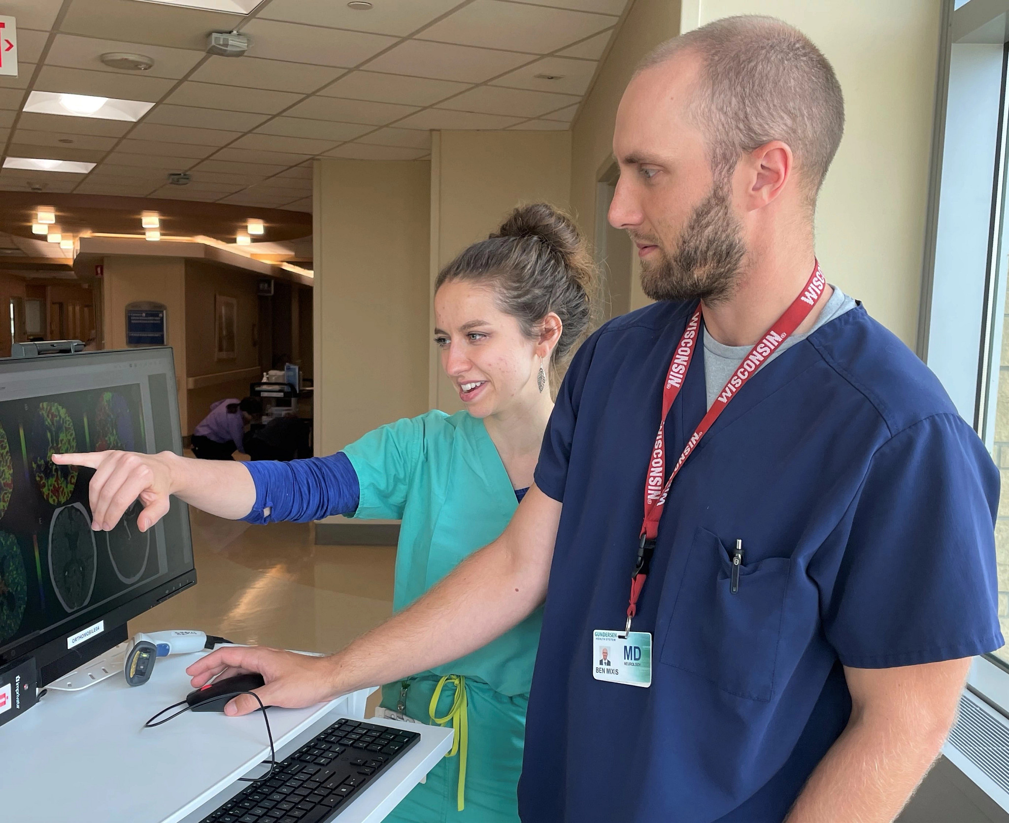 Medical students inspecting neuro image on computer.