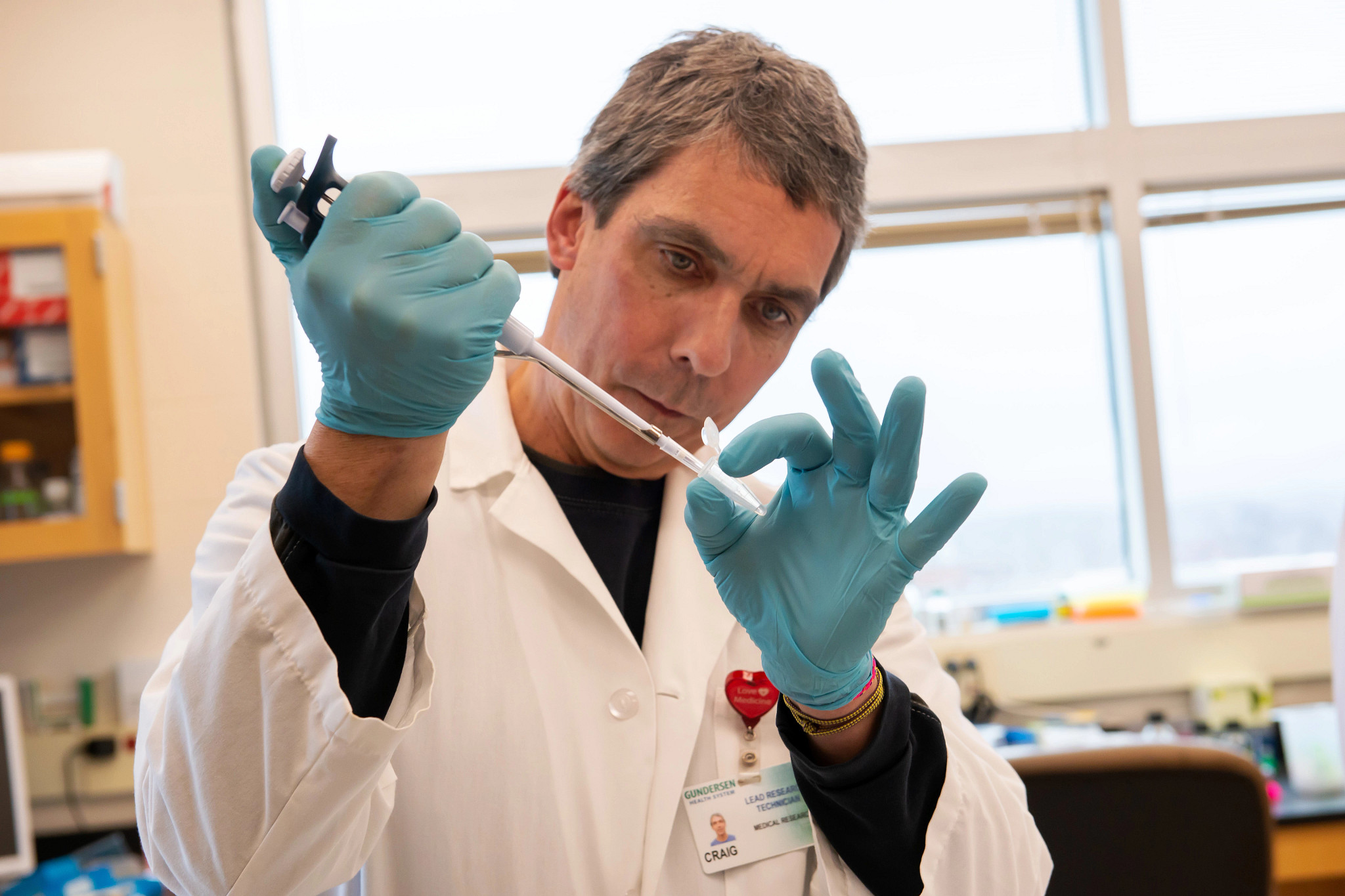 Lab research technician in lab using equipment.