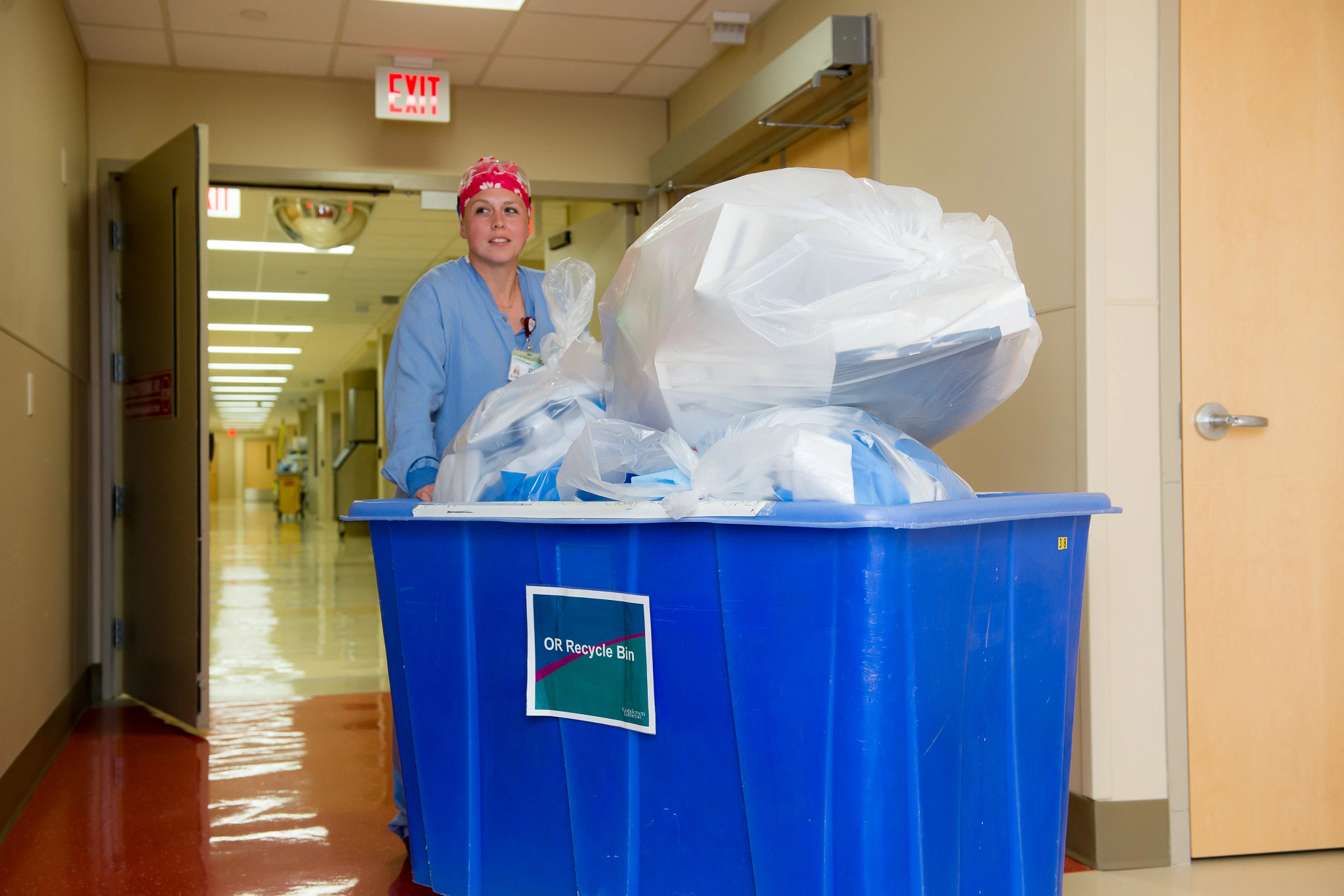 operating room recycling bin being transferred in the hospital by an employee