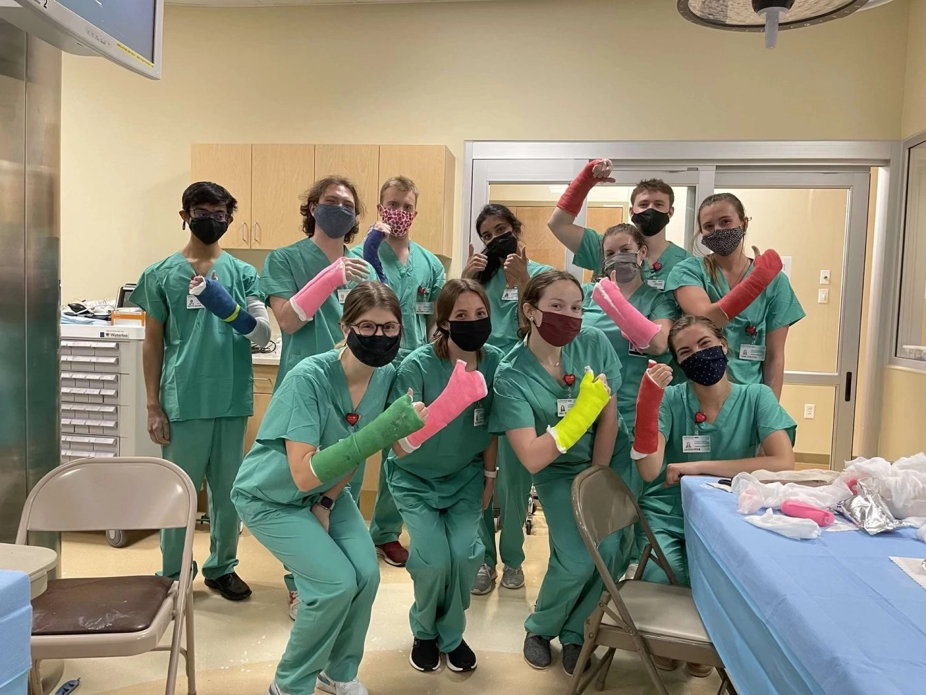 Summer research fellows posing with casts on their arms.
