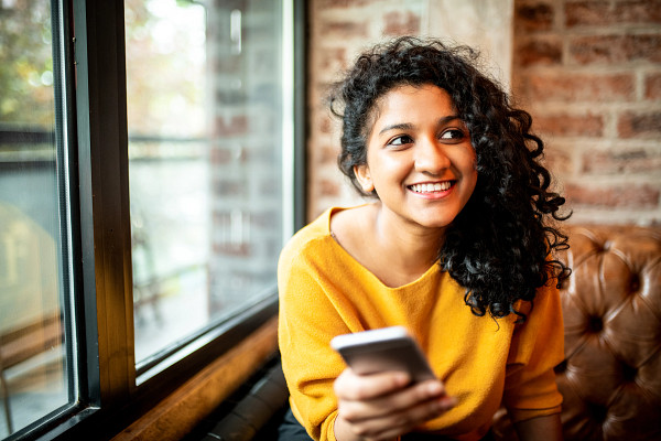 Young woman using mobile phone at coffee shop