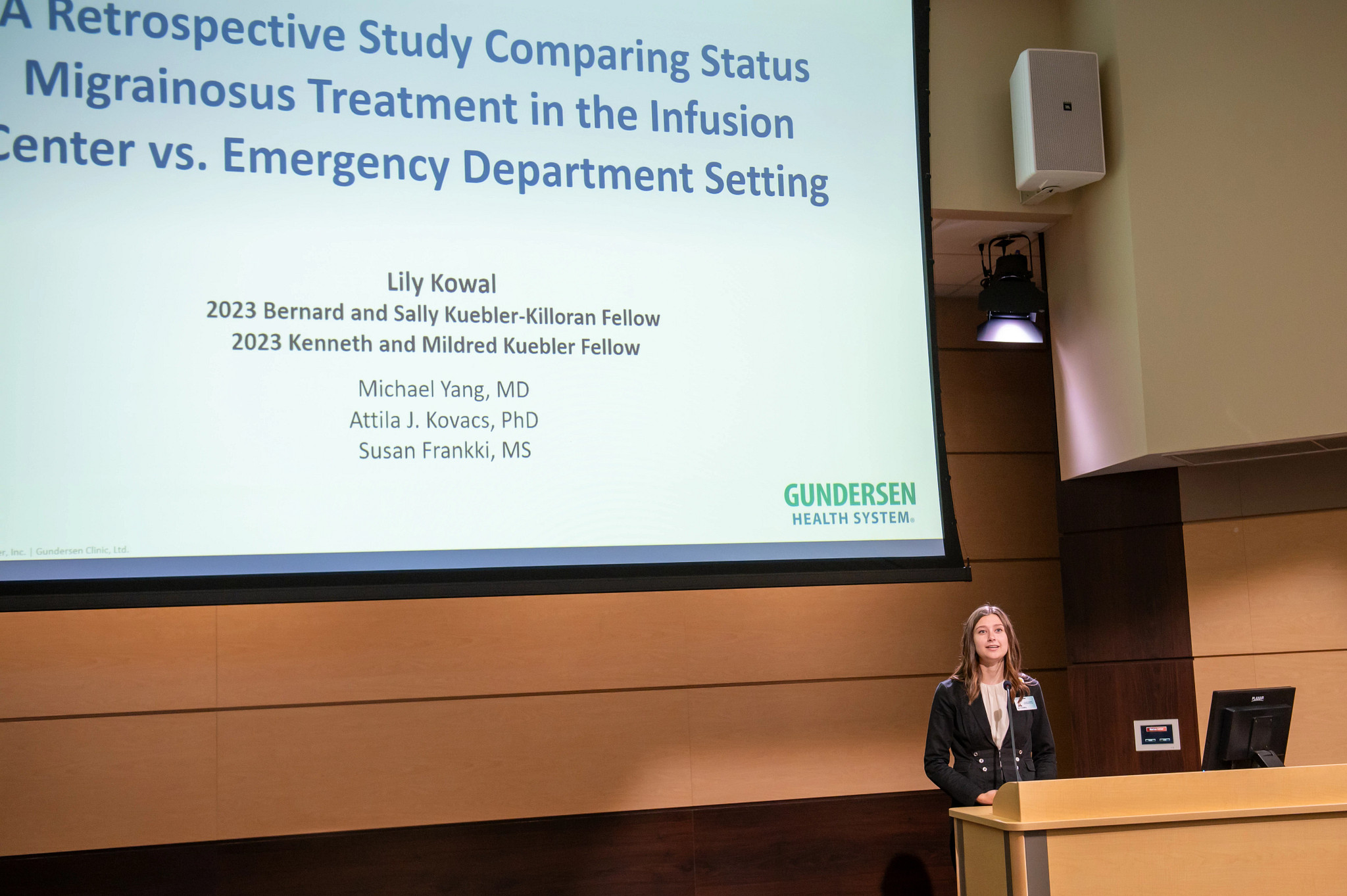 Summer research fellow presenting at podium.