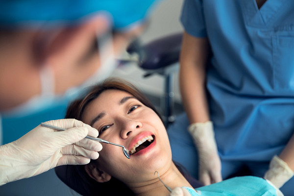 gettyimages-1368735987_dentist-treats-the-young-womens-teeth-in-the-dental-clinic.jpg