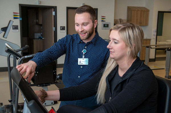 Gundersen exercise physiologist helping patient on exercise bike.