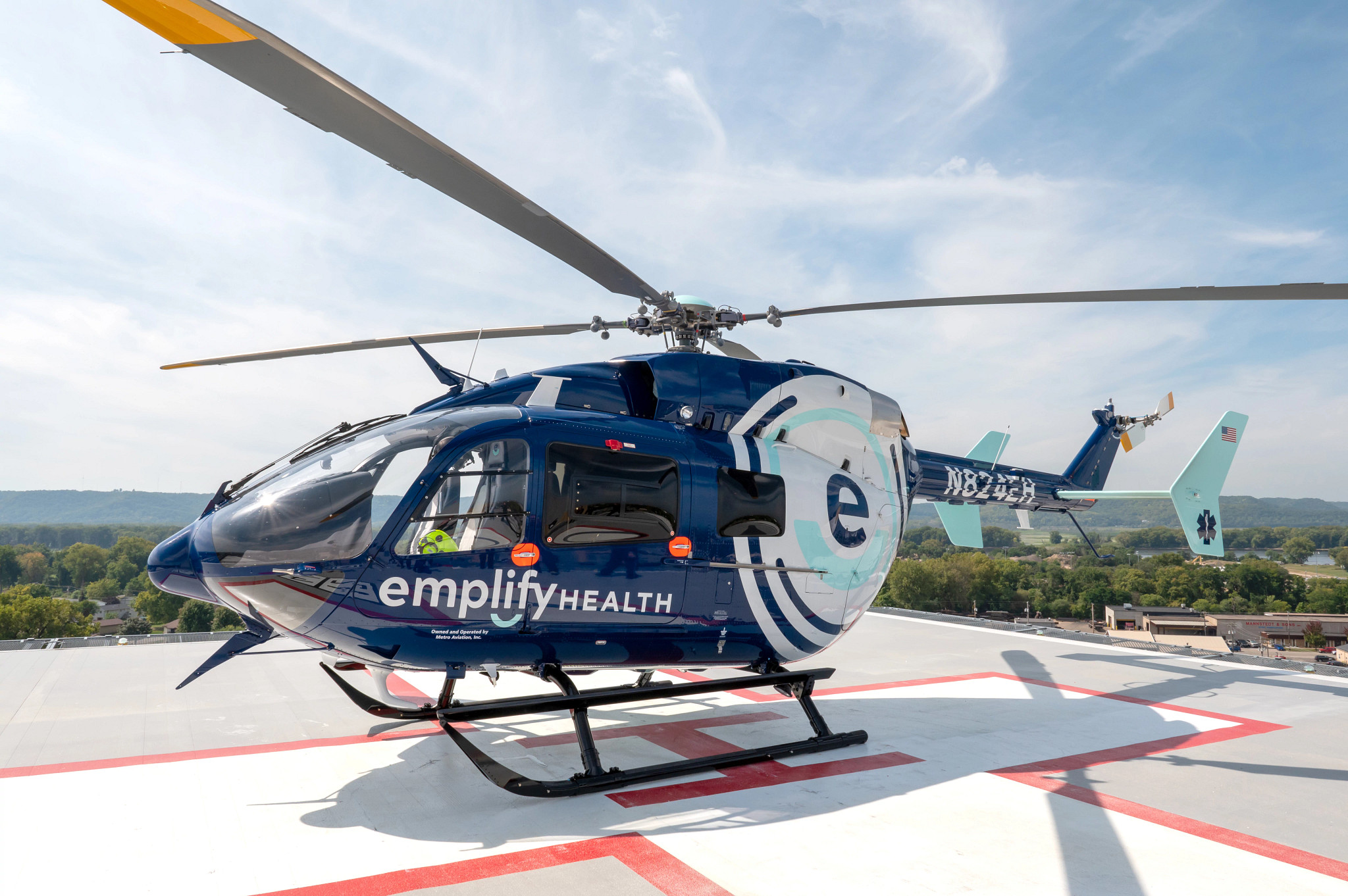 Emplify Health medical helicopter on hospital rooftop helipad.