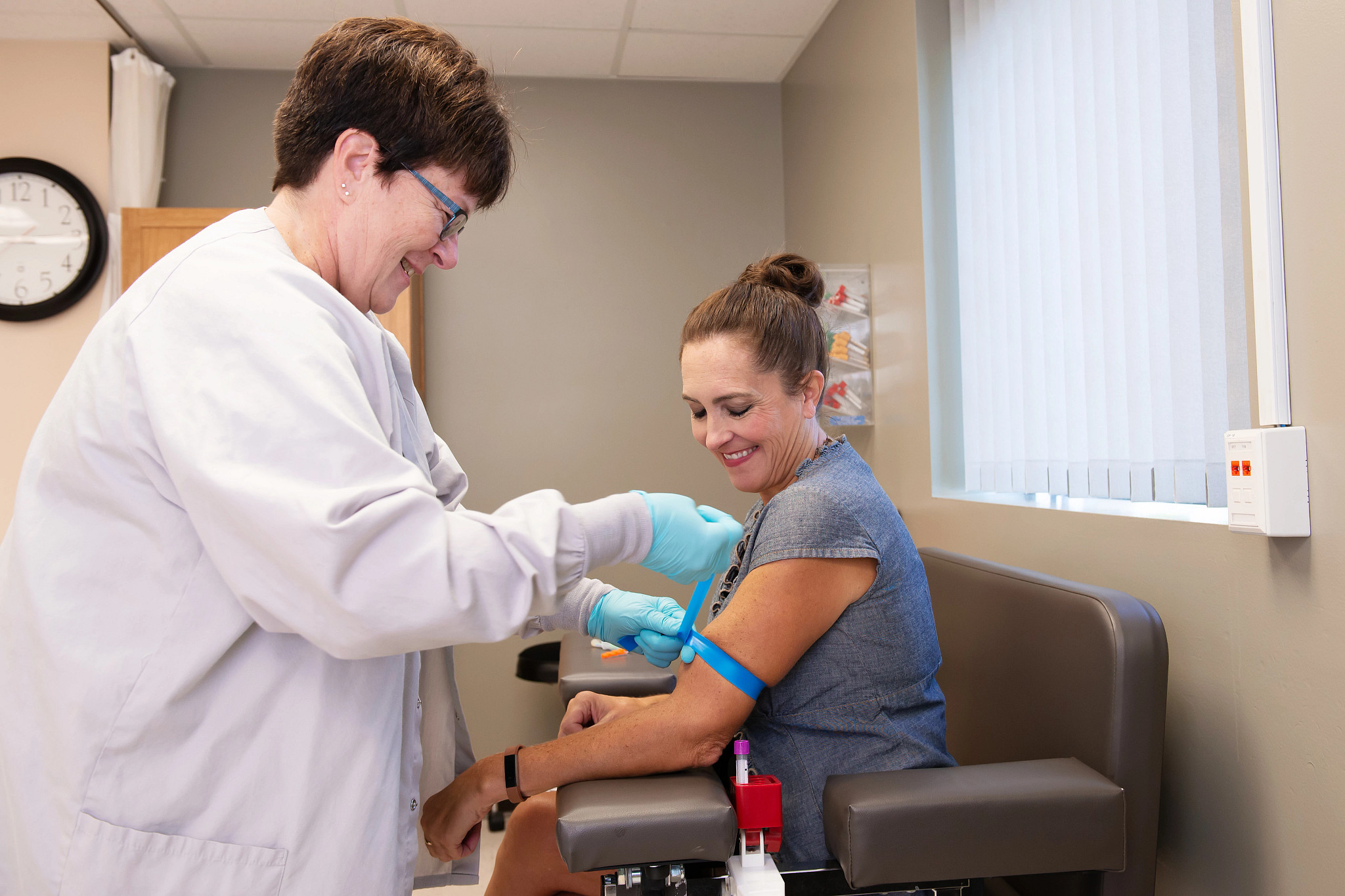 Laboratory technician getting patient ready for blood draw.