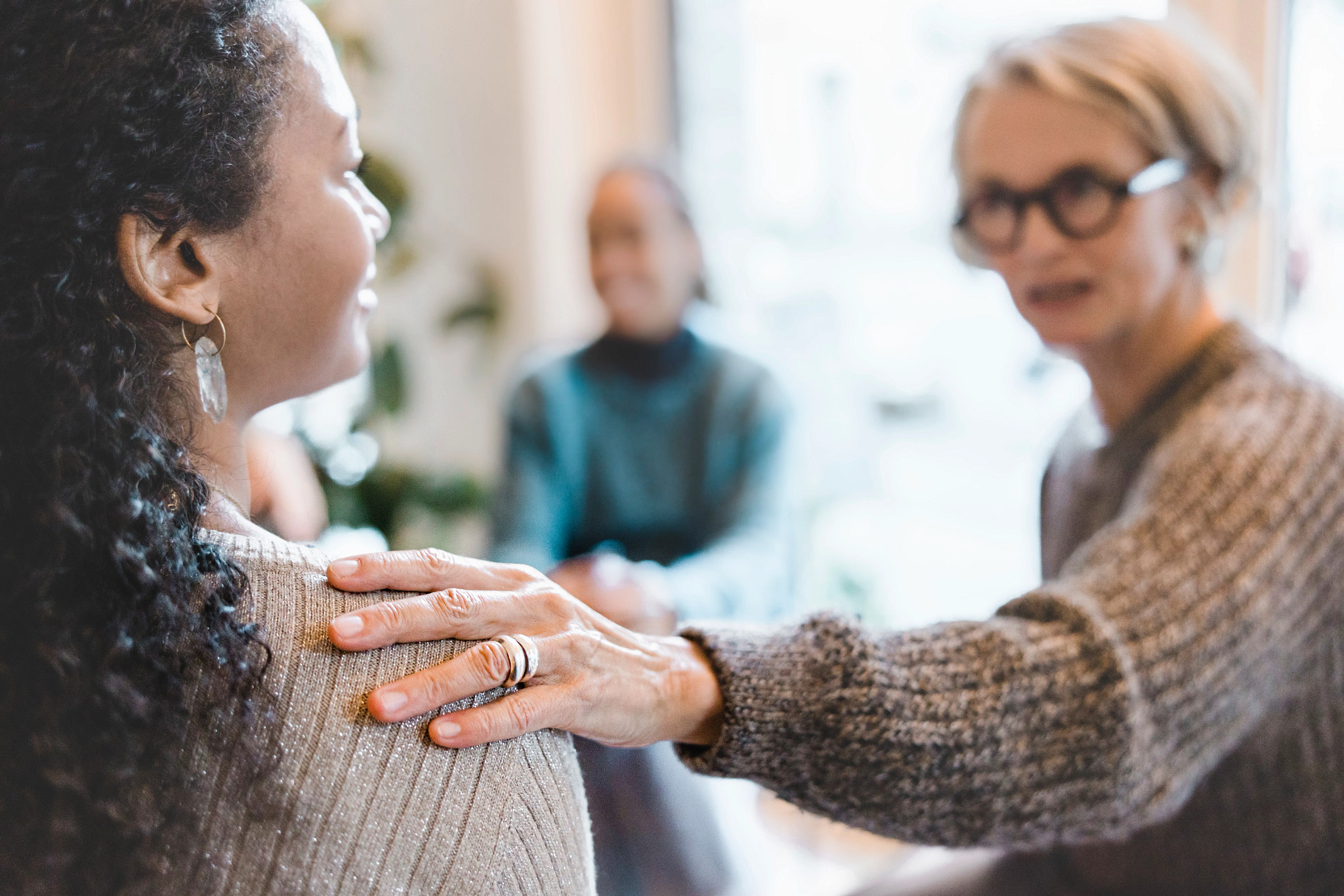 Therapist giving support to a woman during group session