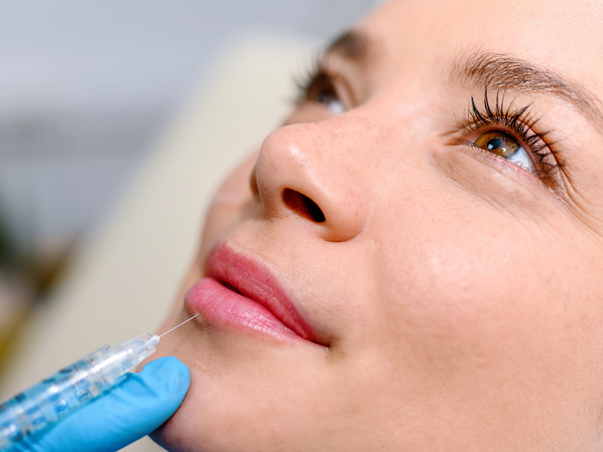 The doctor cosmetologist makes the Rejuvenating facial injections procedure for tightening and smoothing wrinkles on the face skin of a beautiful, young woman in a beauty salon.