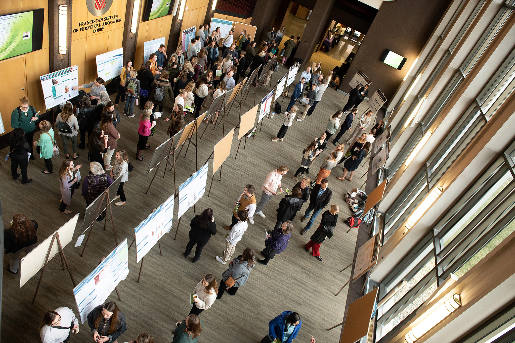 Presenters and research boards at nursing research event.