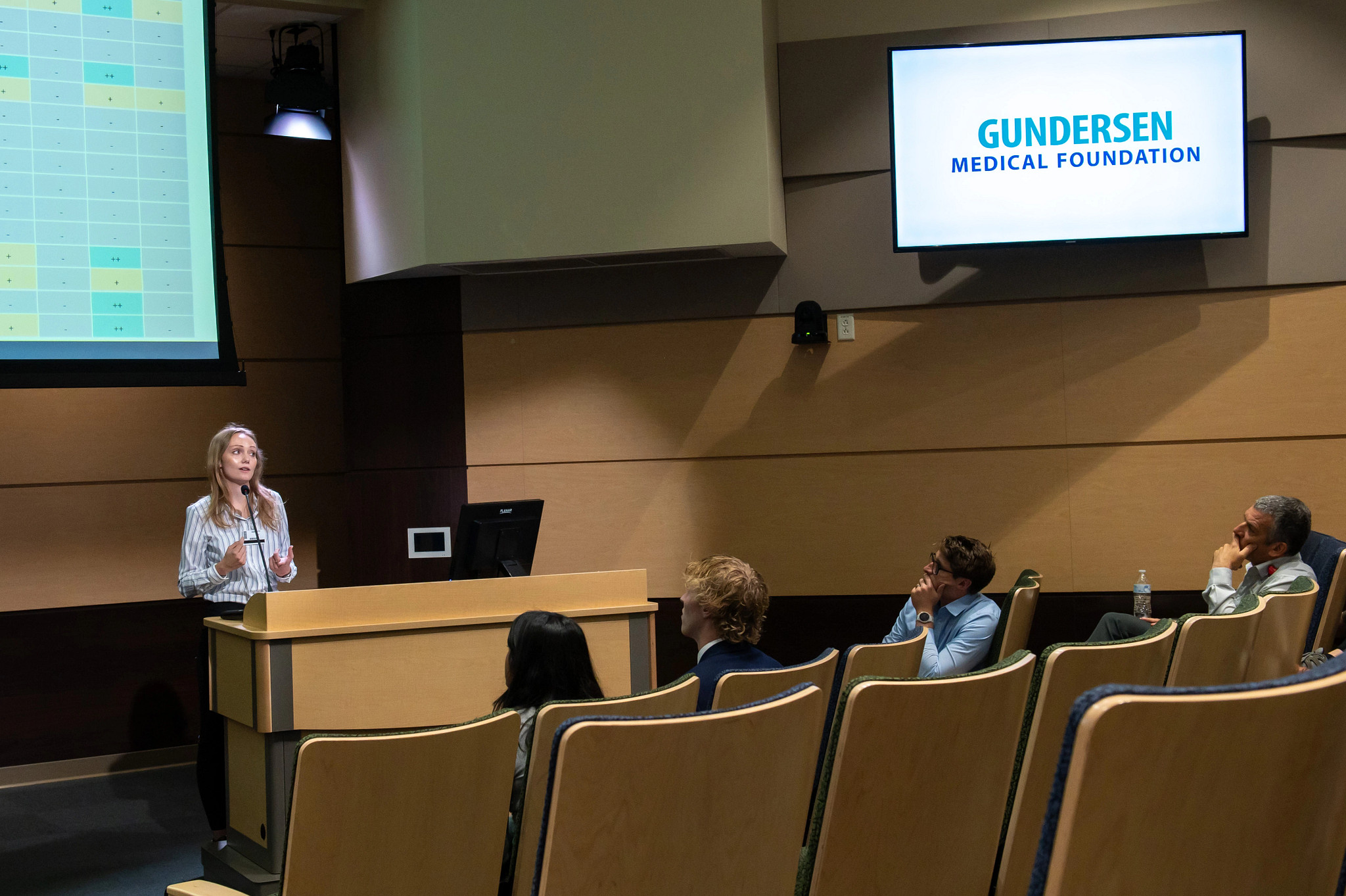 Summer research fellow presenting in auditorium.
